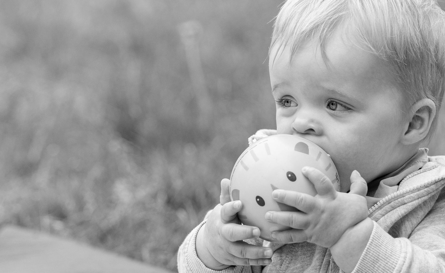 Black and white photo series showing a small child playing with a toy and making various playful expressions.