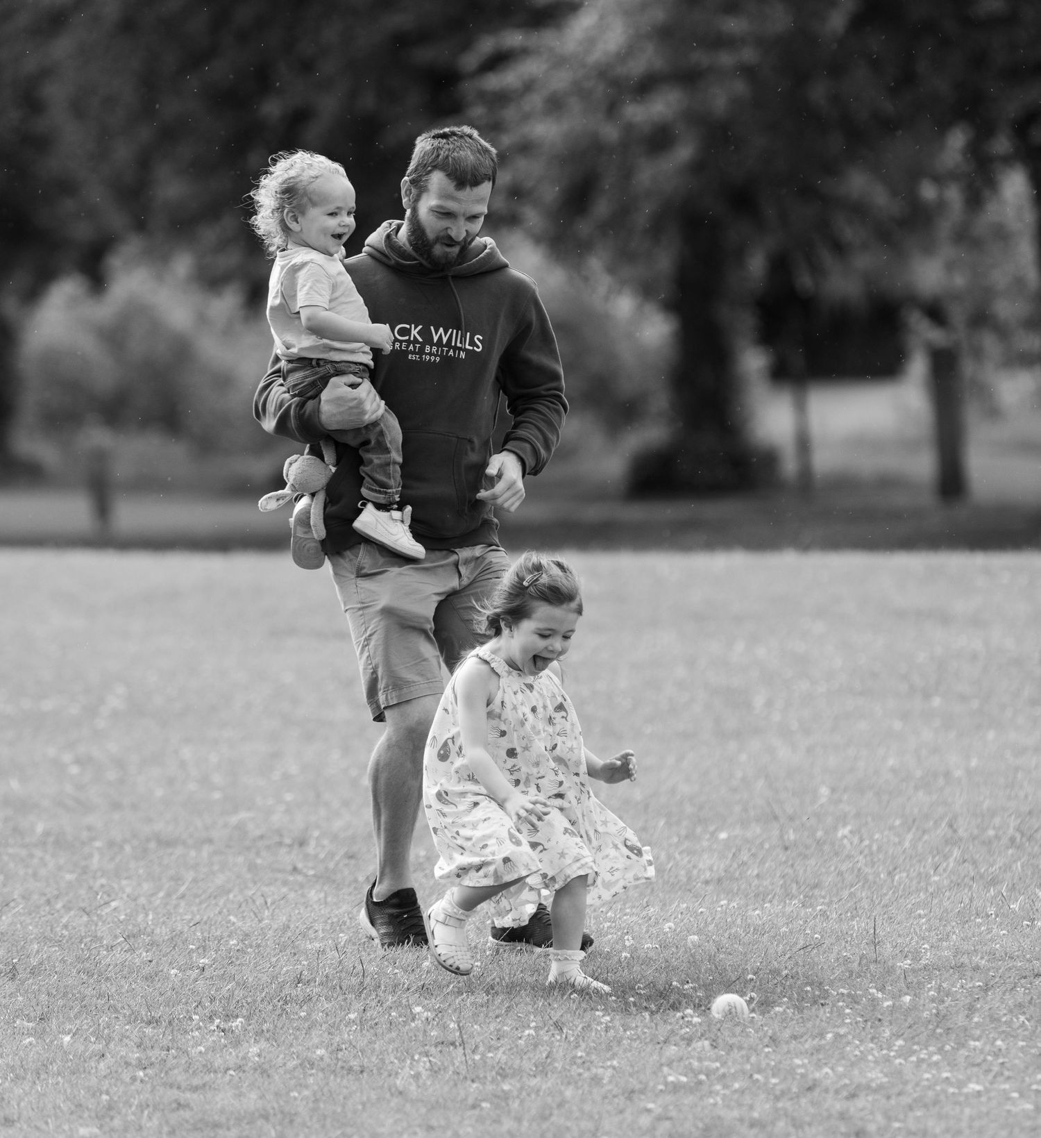 A sequence of black and white photos showing people playing and running in a grassy field.