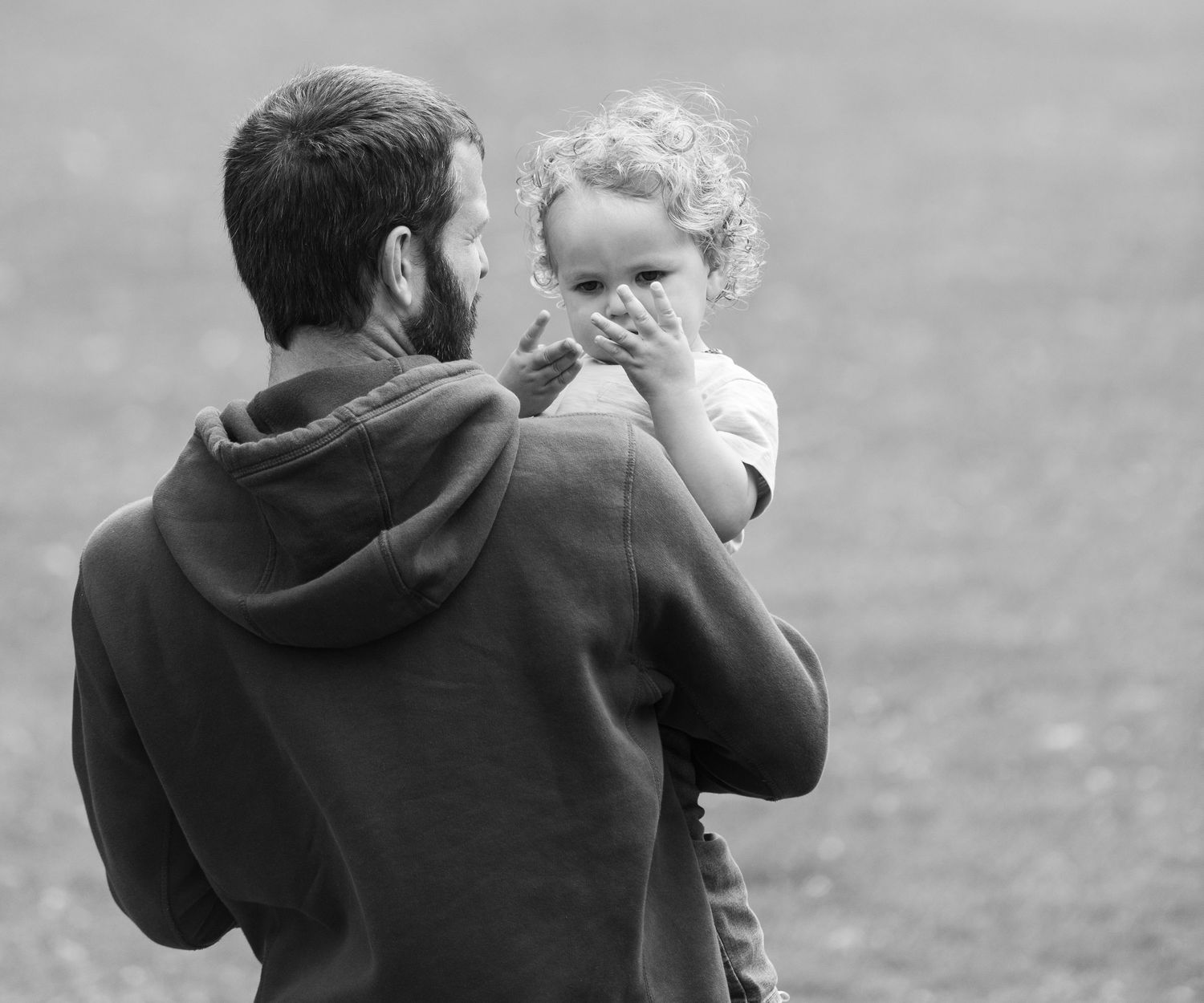 Black and white series showing someone carrying a child outdoors.