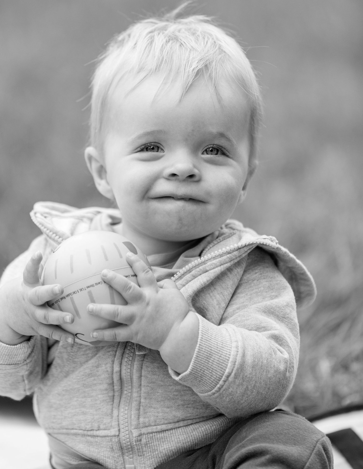 A sweet moment captured in black and white of a small child holding a toy.