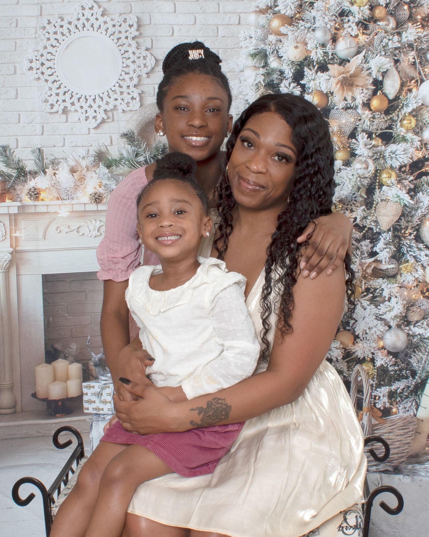 Three generations of women pose together near a decorated Christmas tree in a festive holiday portrait.