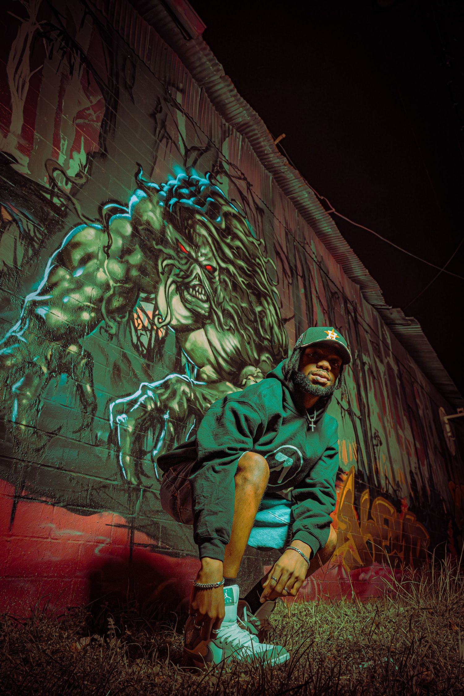 A series of green-lit statues or figures crouch menacingly in a dark, spooky outdoor setting at night.