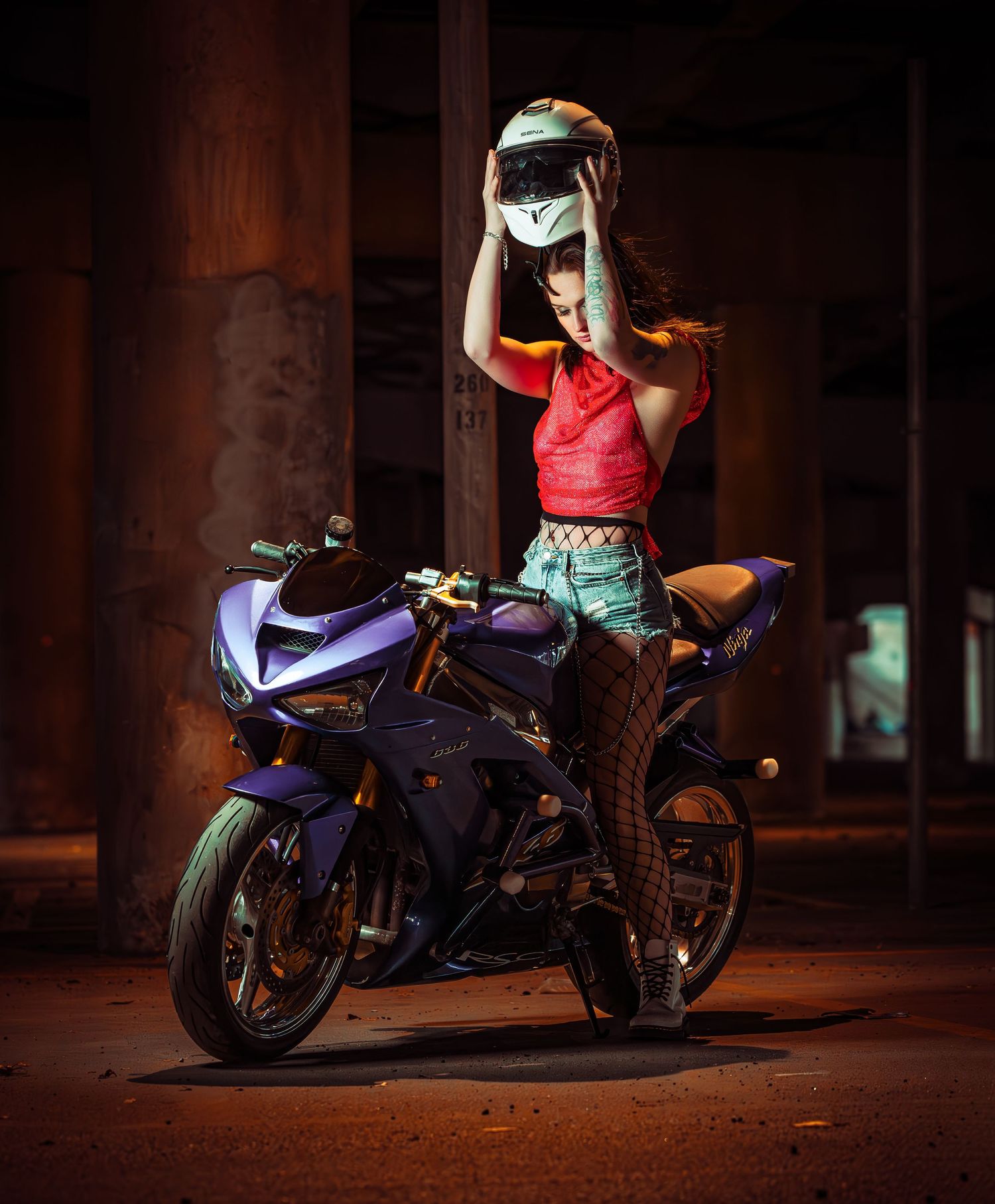 Purple sportbikes parked in a dimly lit garage or warehouse setting with dramatic lighting.