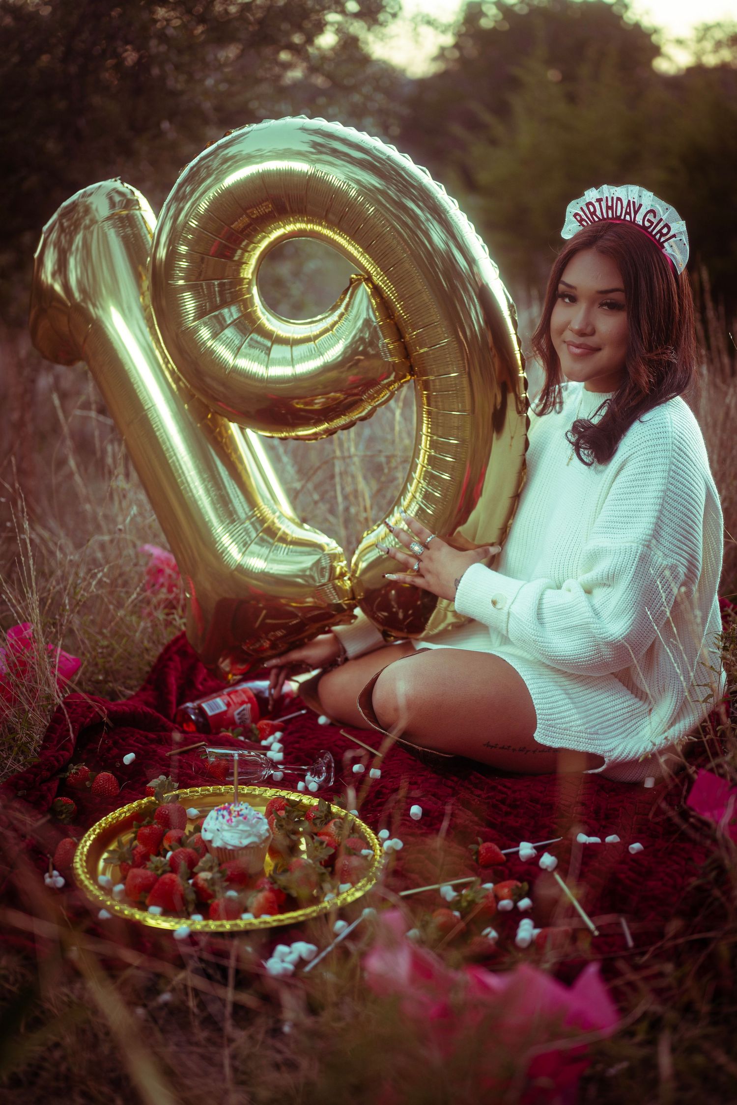Dreamy outdoor photo series with gold number balloon and pink flowers creating a romantic garden setting.