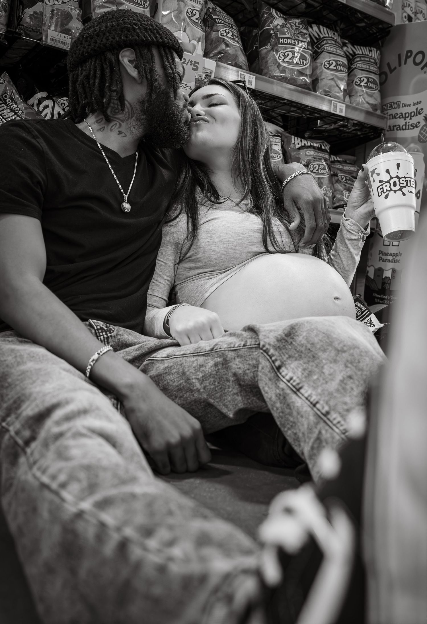 Black and white photo of people relaxing together in a casual indoor setting.