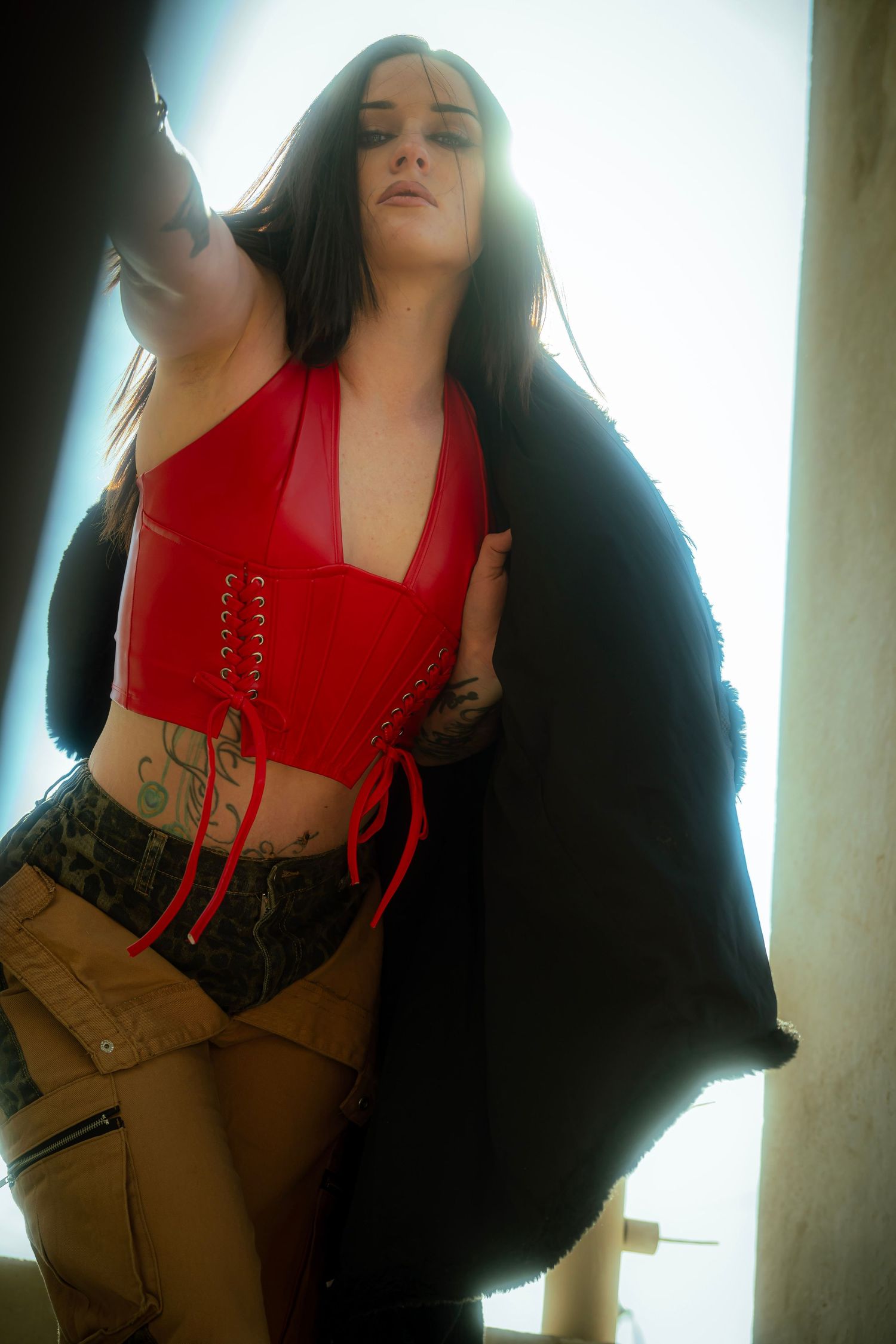 Artistic portrait series showing person in red top against bright backlit background.
