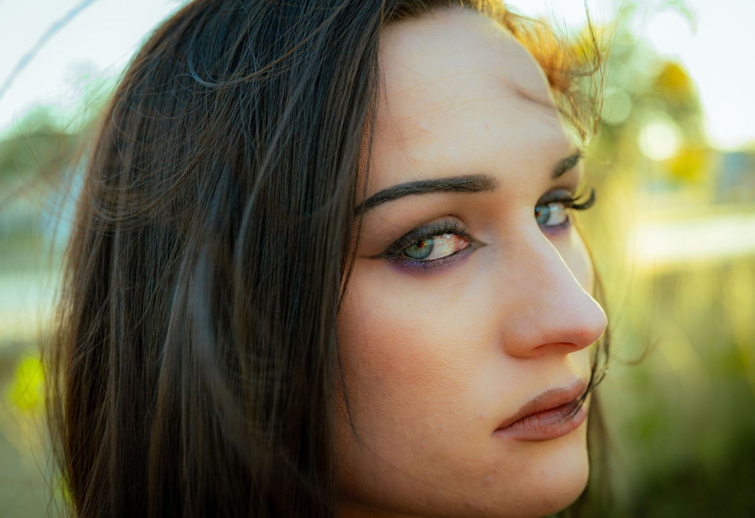 Close-up beauty shot with dramatic lighting highlighting striking eyes.