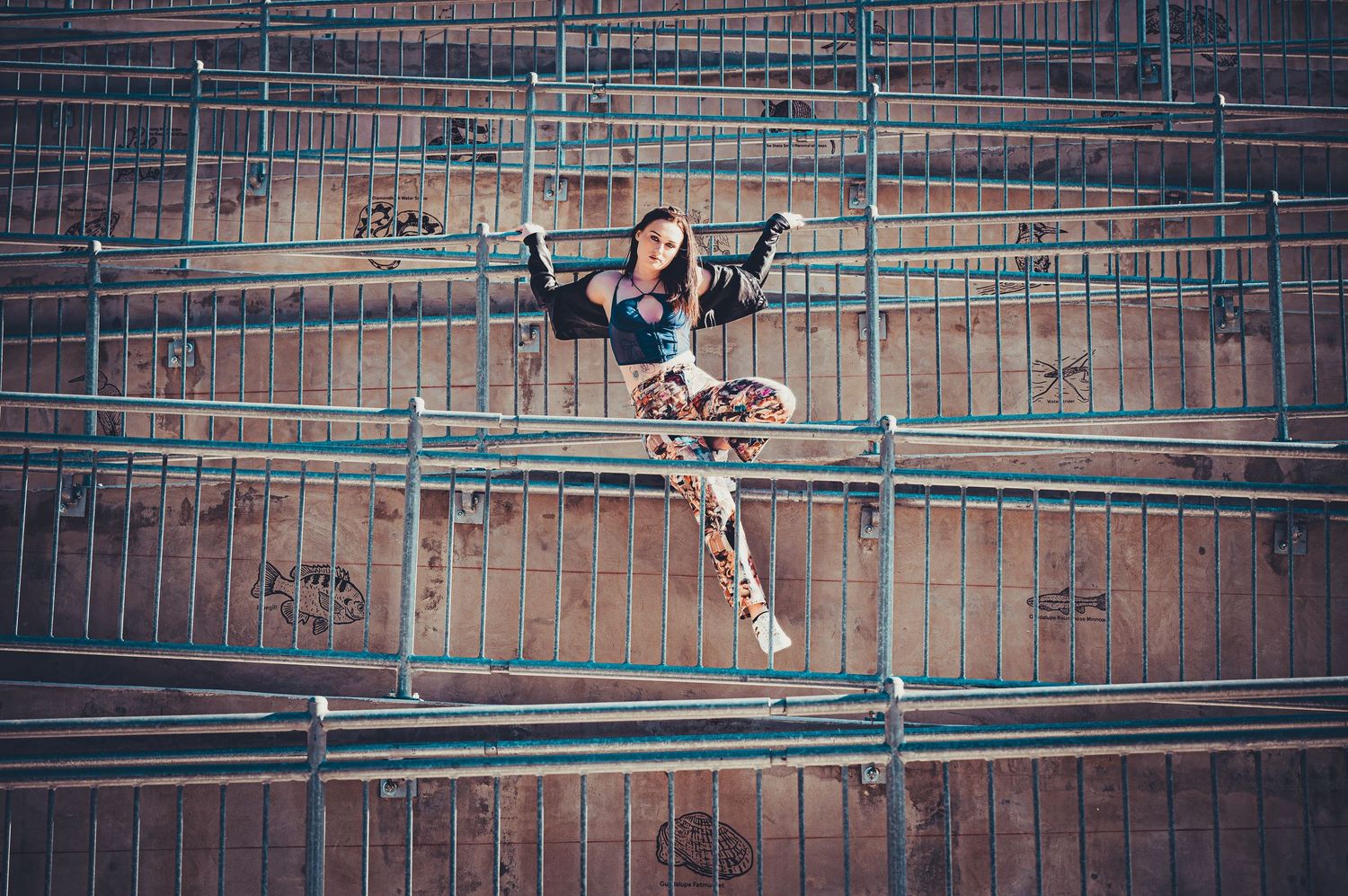 Person performing acrobatic moves on metal bars against brick wall background.