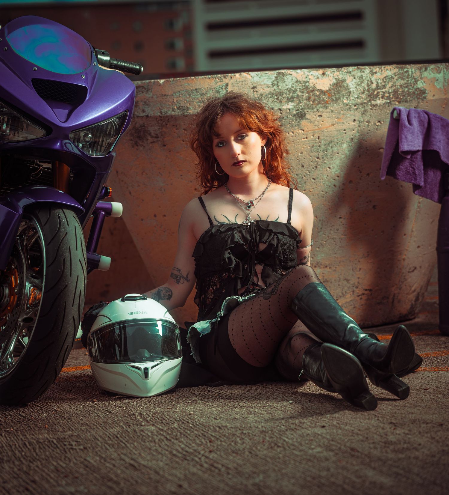 A series of motorcycle helmets and boots lined up against a weathered wall in dim lighting.