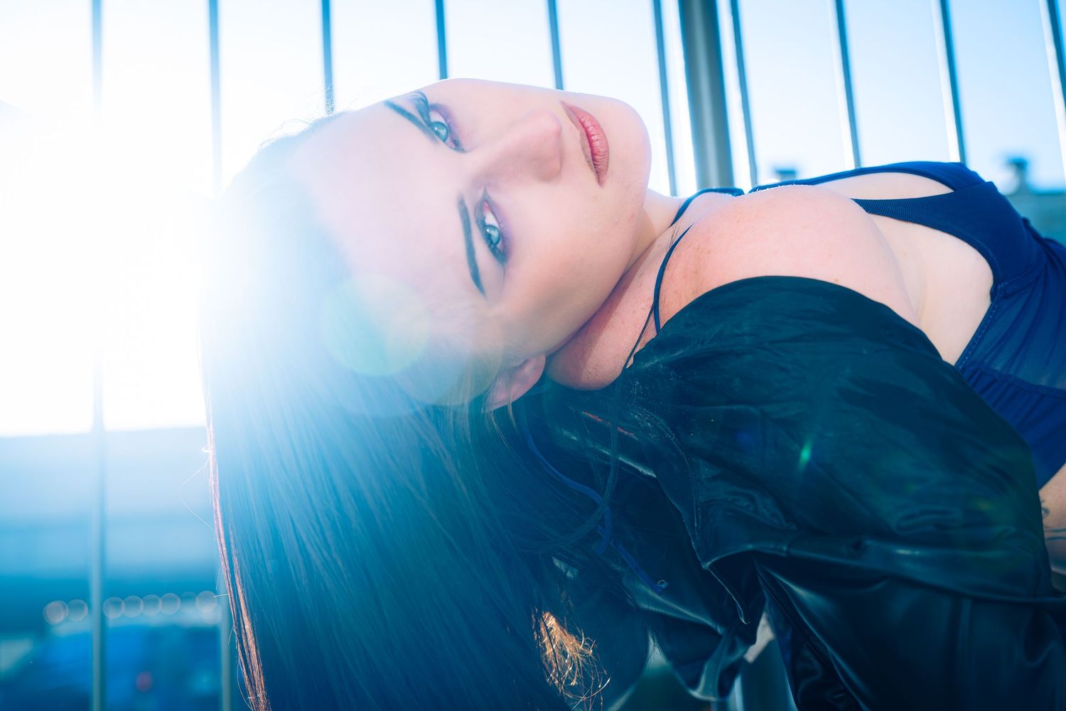 Artistic portrait with soft blue tones and dramatic side lighting.
