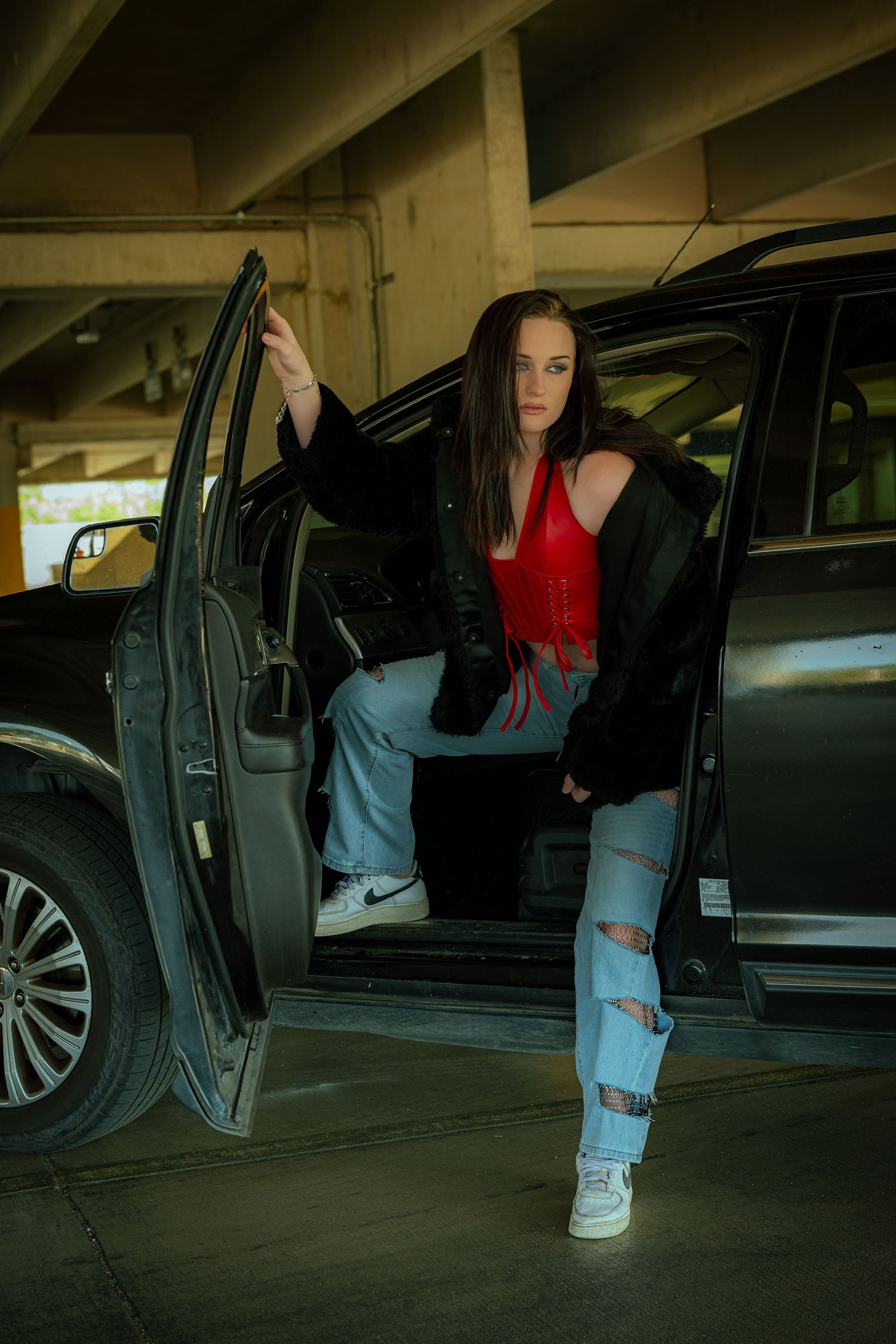 Urban fashion sequence in parking garage with car and denim details.