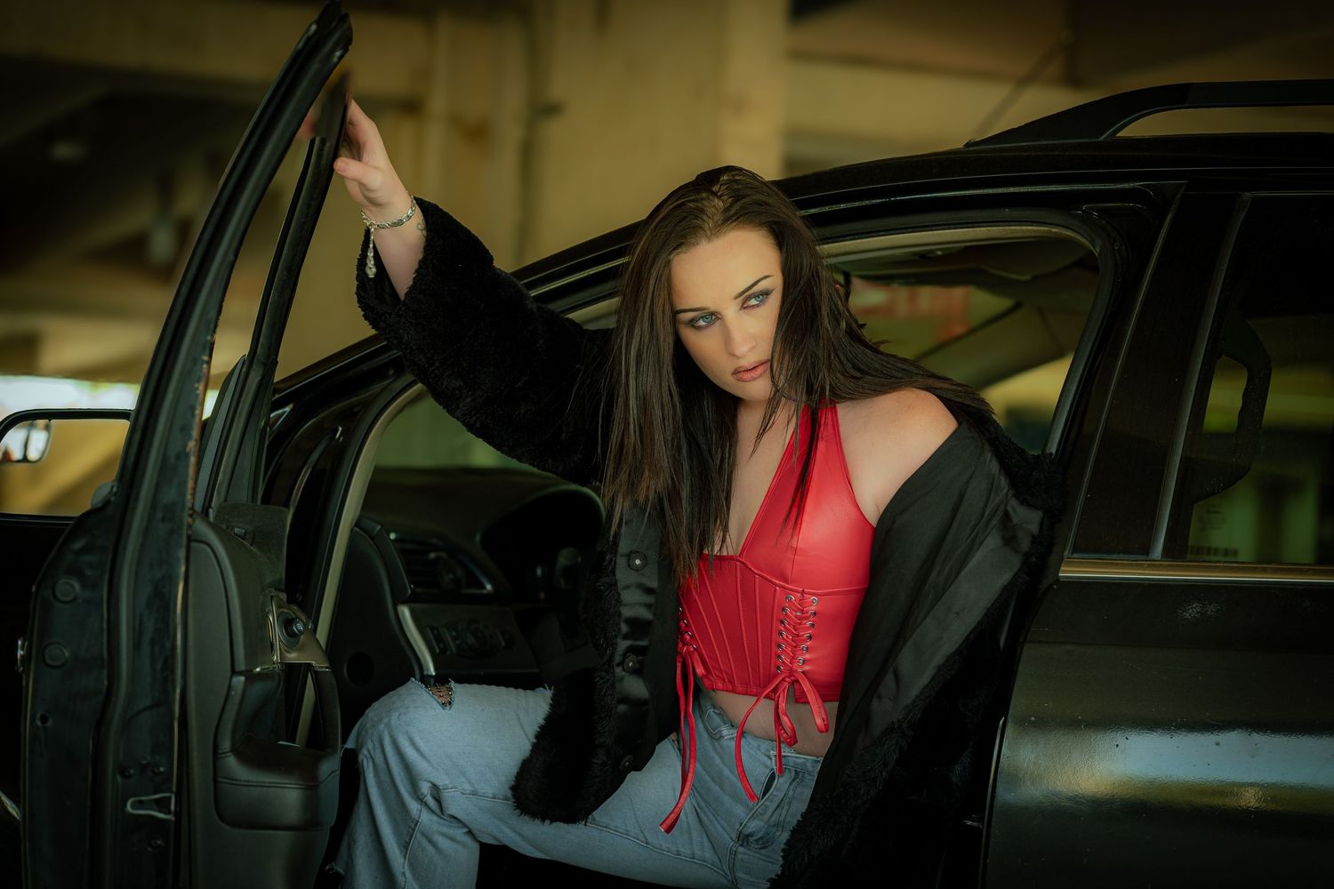 Fashion editorial shots in dimly lit parking structure with vehicle.