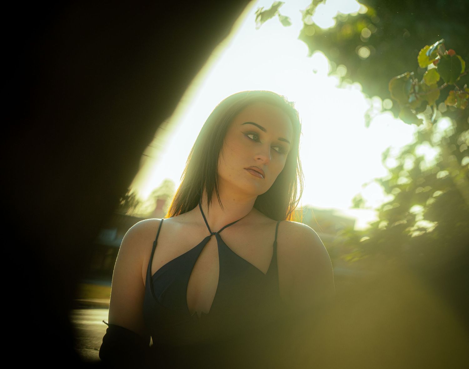 Ethereal backlit portrait with glowing green foliage in background.