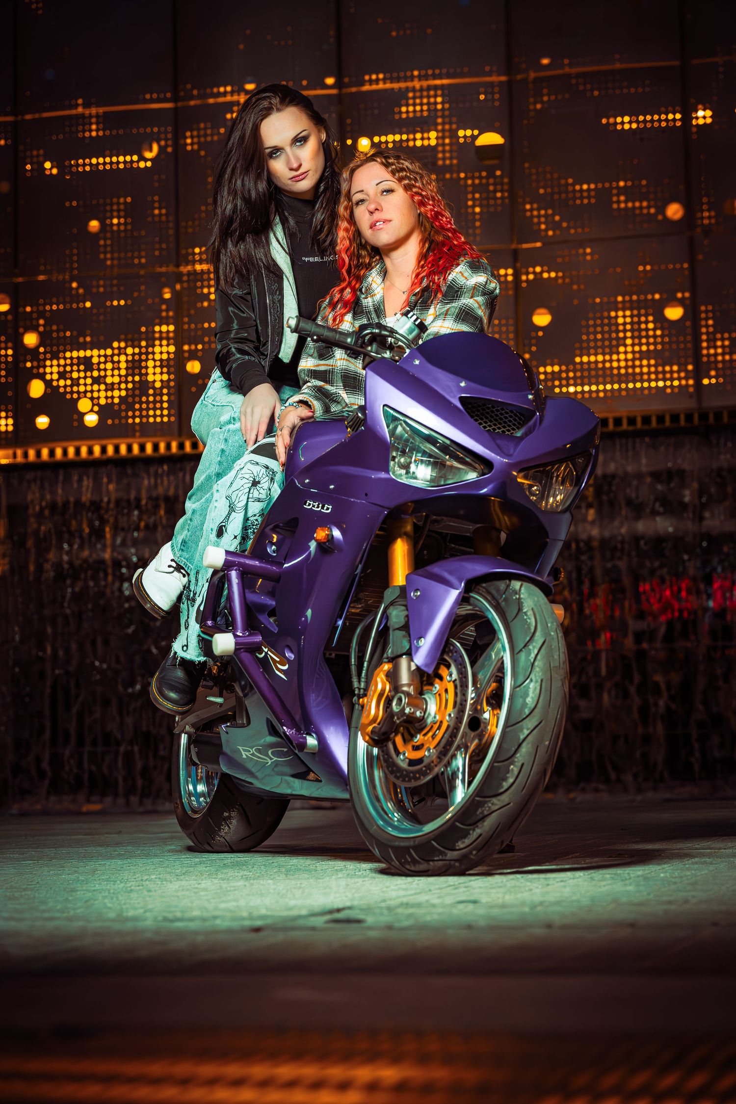 A sleek purple sports motorcycle parked at night with dramatic lighting and glowing lights in the background.