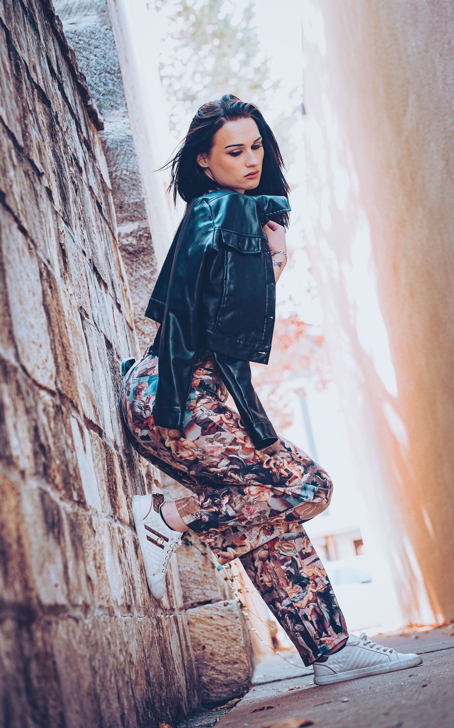Fashion portrait against textured wall showing dynamic poses and movement.