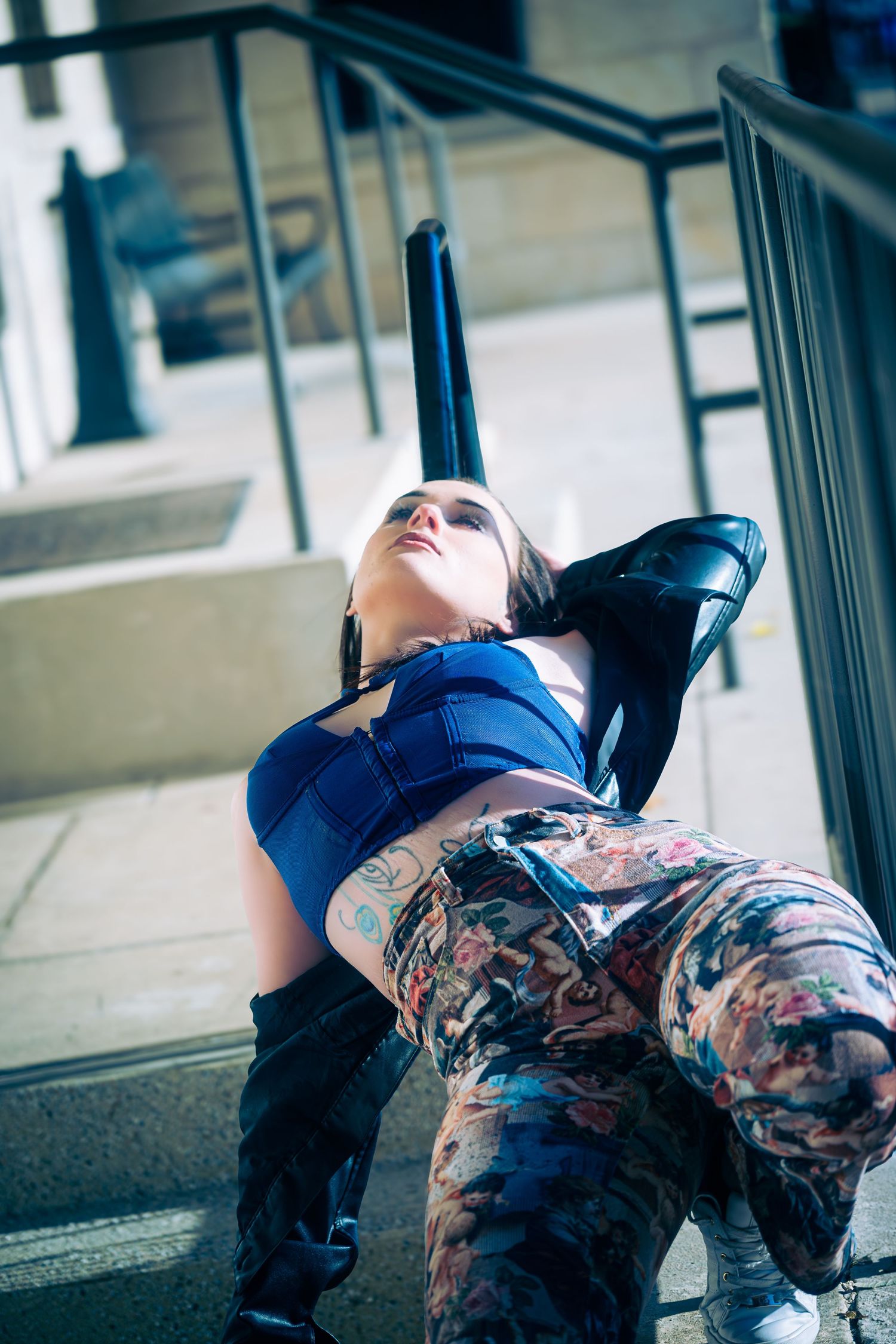 Fashion photography on concrete floor featuring patterned pants and blue top.