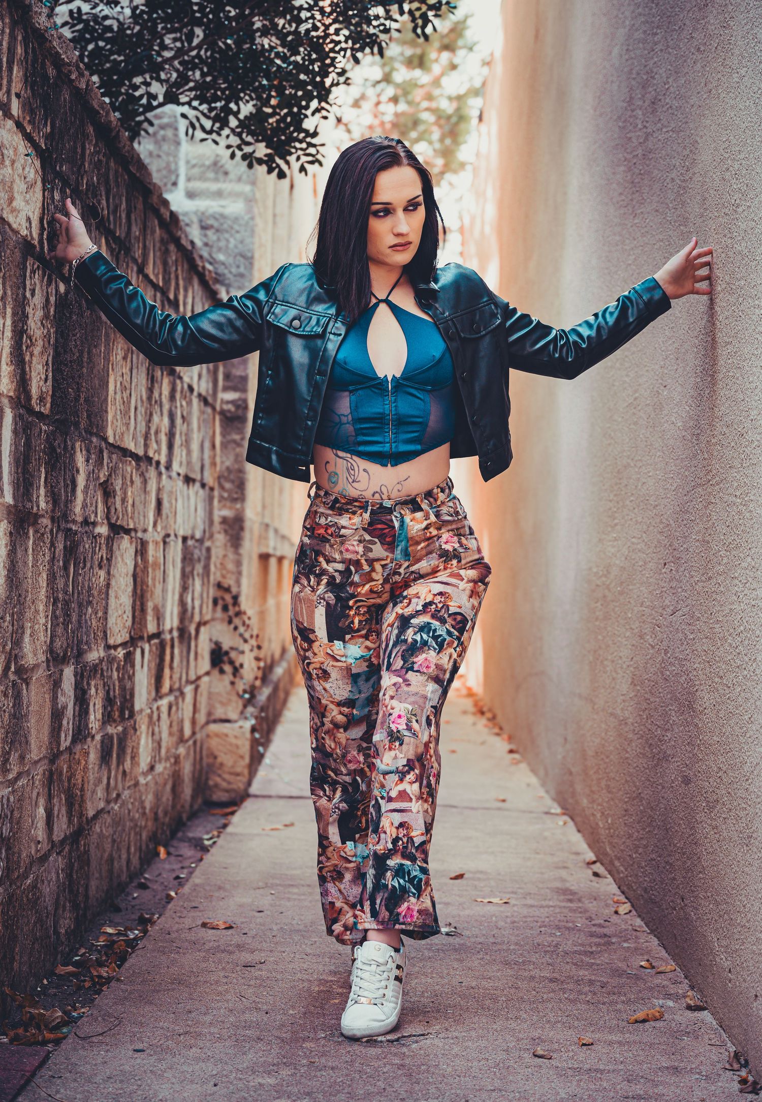 Urban fashion shoot in narrow alleyway featuring patterned pants and casual style.