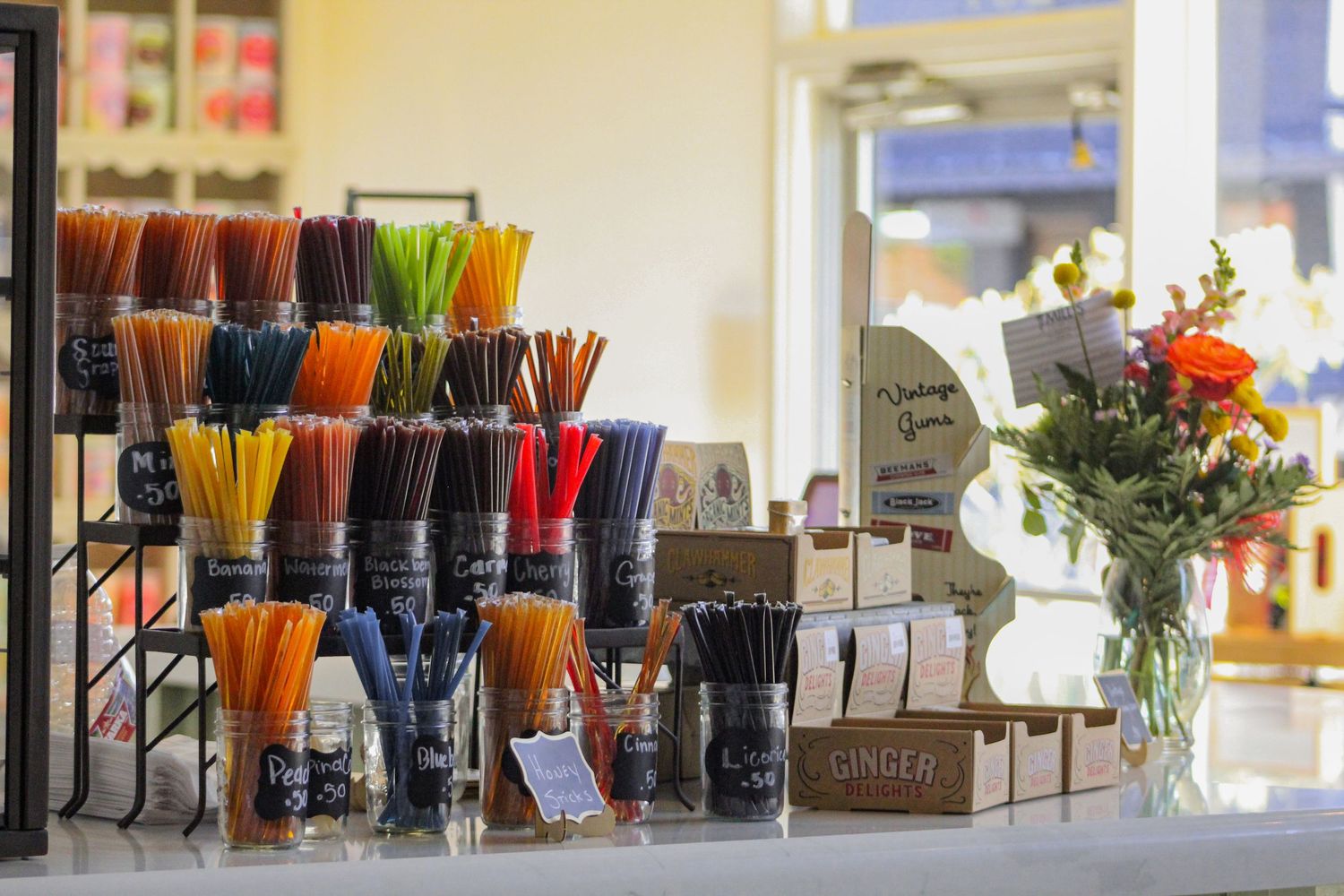Colorful honey sticks are stacked in rows sitting on a counter.