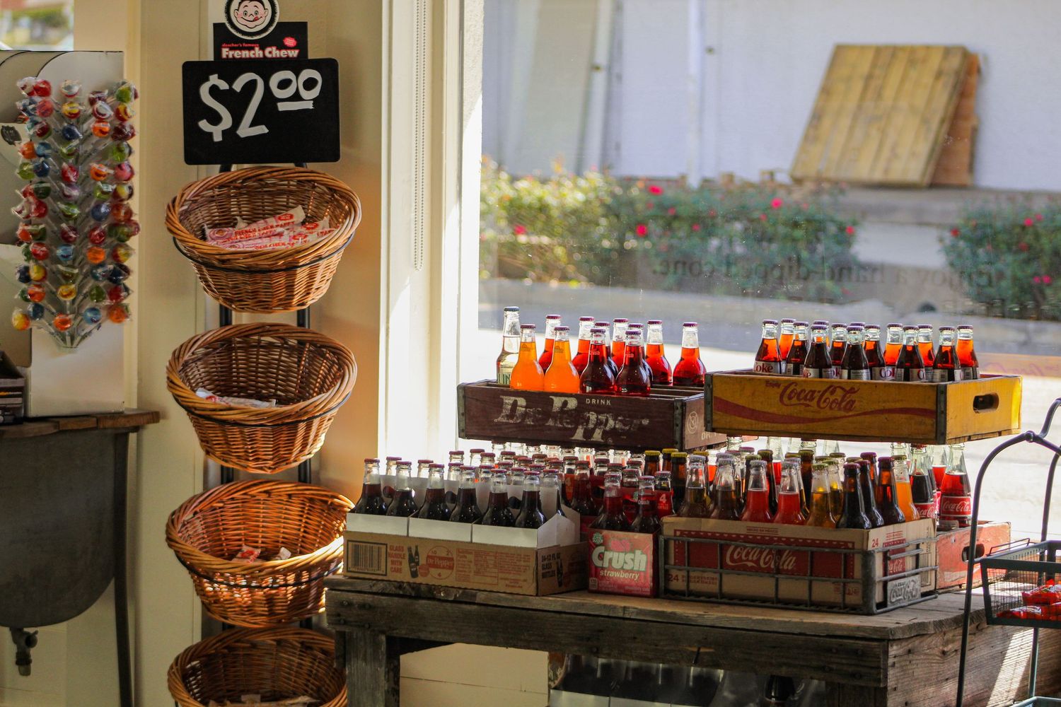 Image of a candy shop with lots of bright colored drinks and candies in various baskets.