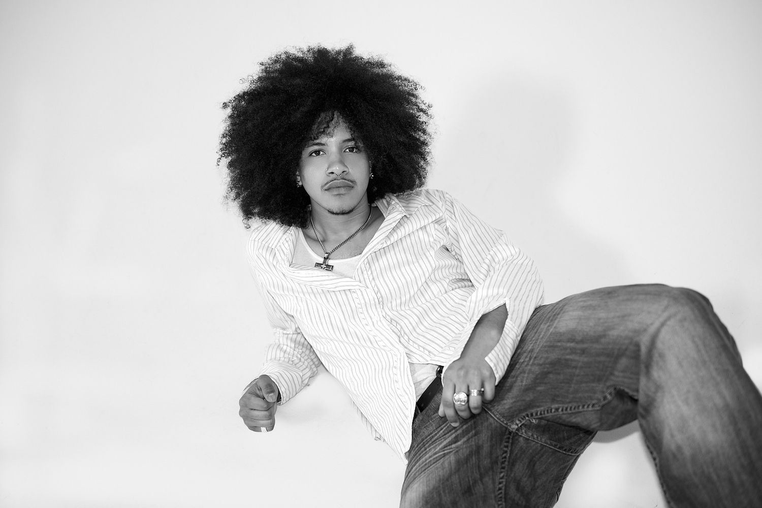 A black and white photo series showing someone with natural curly hair in various casual poses and expressions.