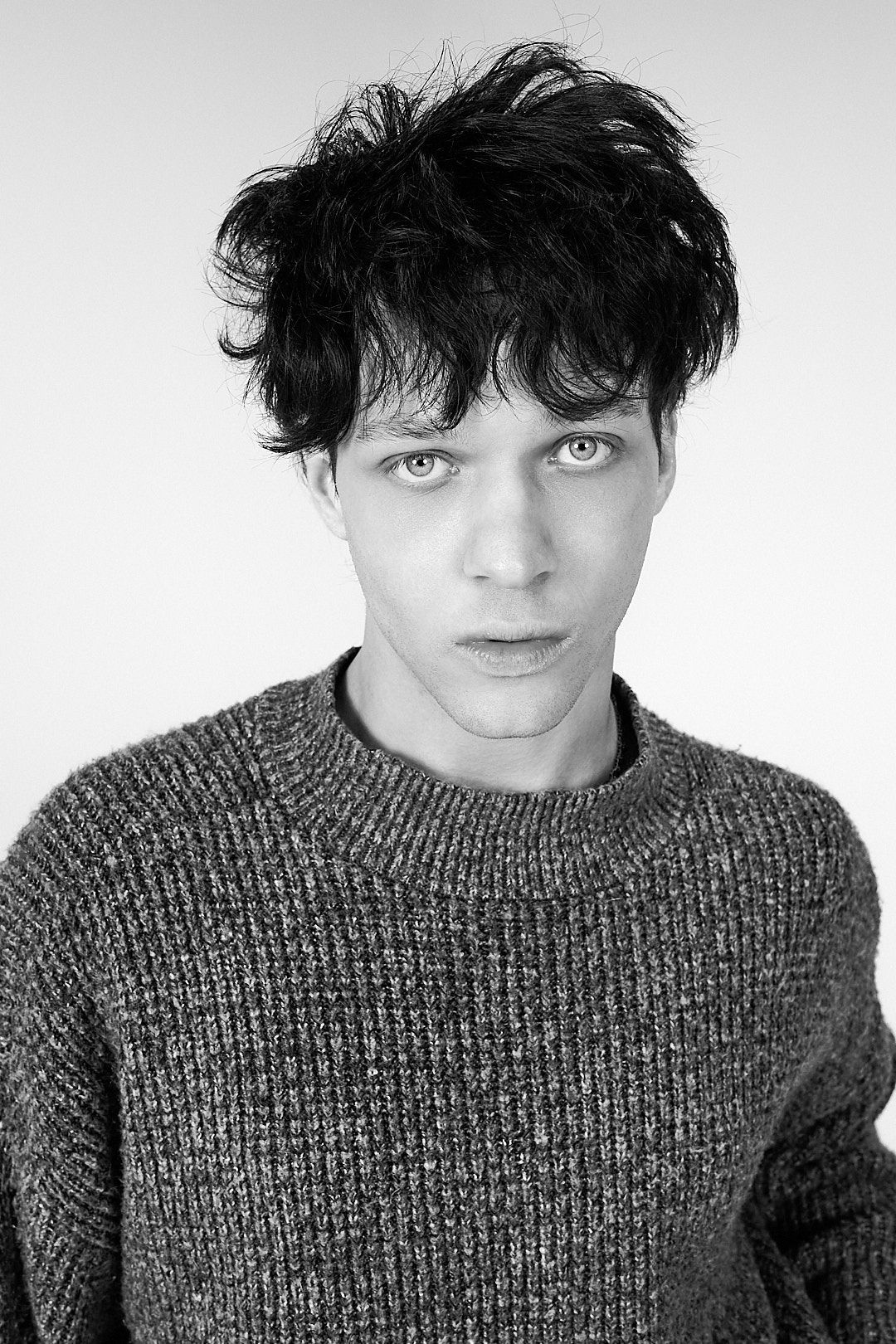 Close-up black and white portraits showing different angles in a knit sweater against white background.