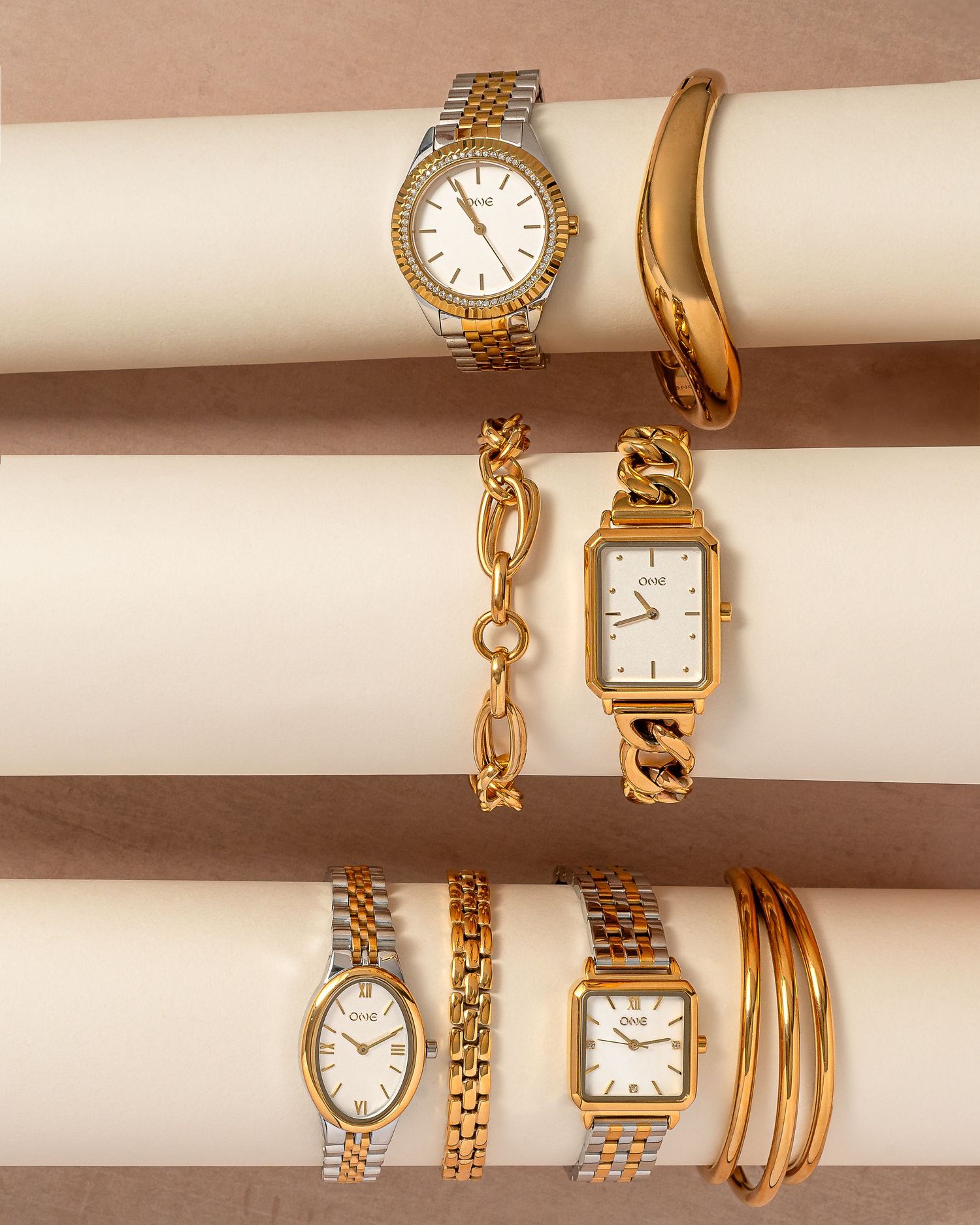 Collection of elegant gold watches and bracelets displayed on beige surface.