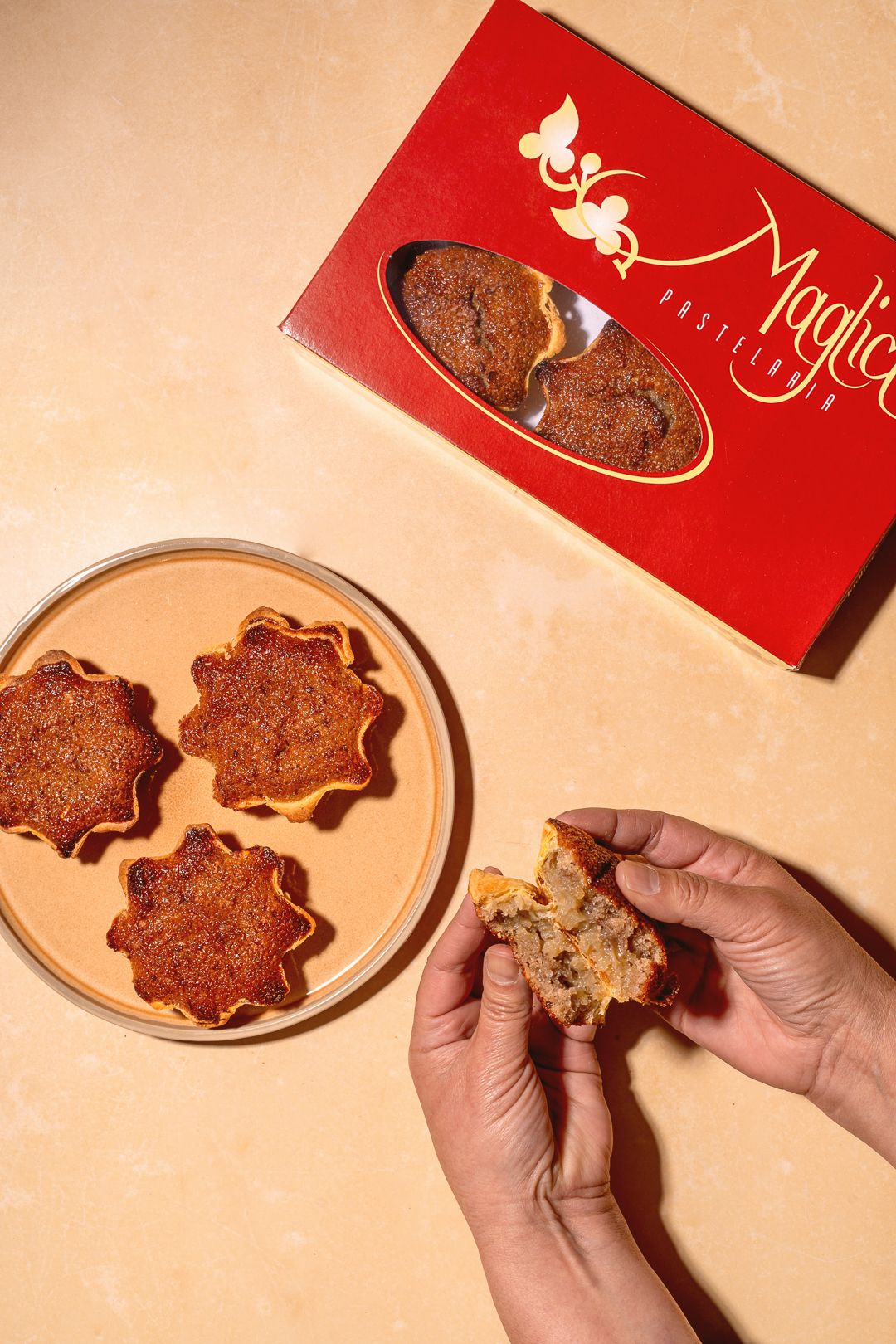 Flower-shaped cookies being broken open to reveal filling on plates.