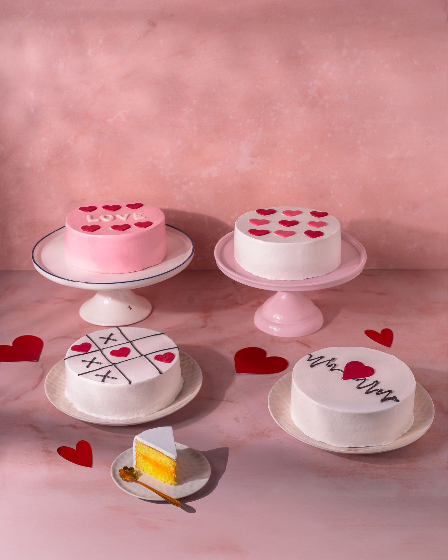 Valentine's themed cake stands with heart decorations on pink background.