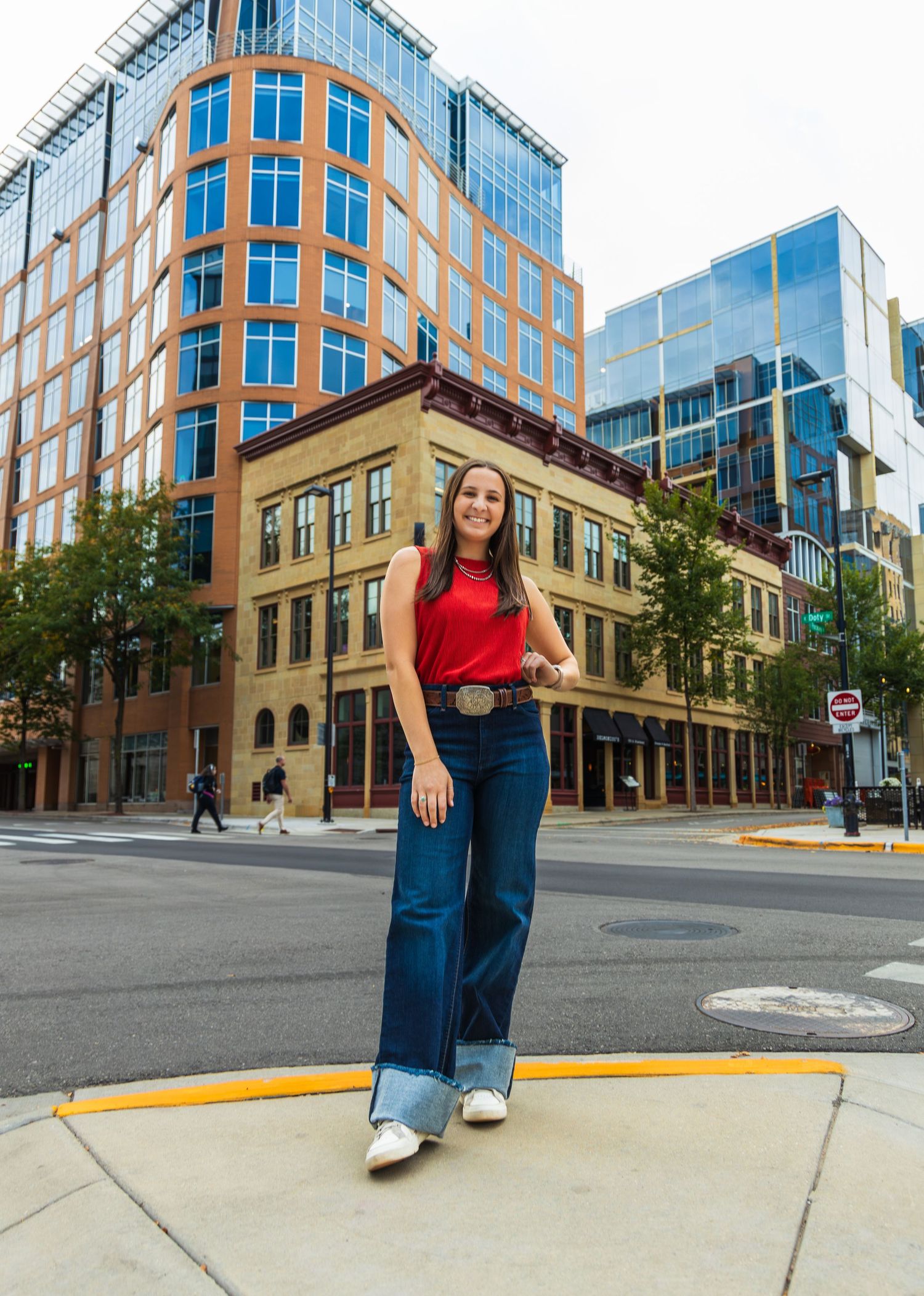 Girl standing on a street corner, posing for the camera.