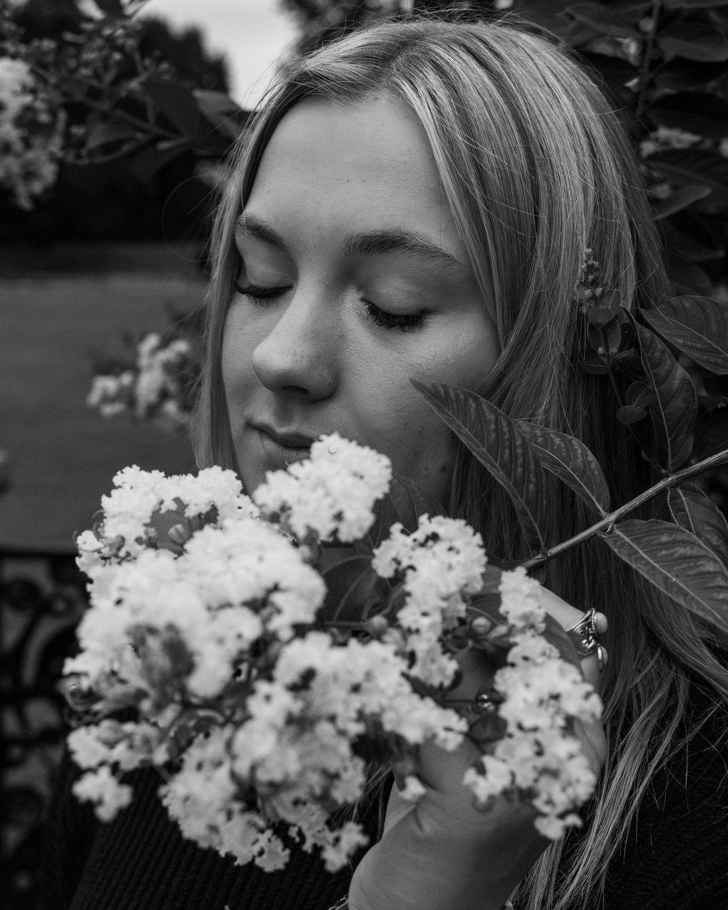 A girl holding a flower in front of her face.