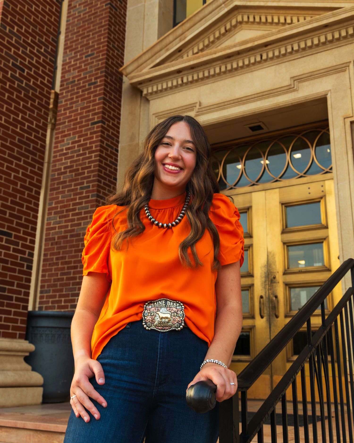 A girl standing on stairs in front of a library door way.