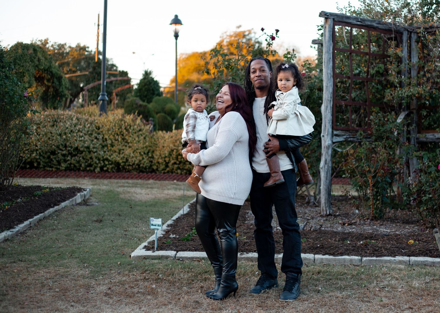 portrait of young family mom and dad holding their daughters