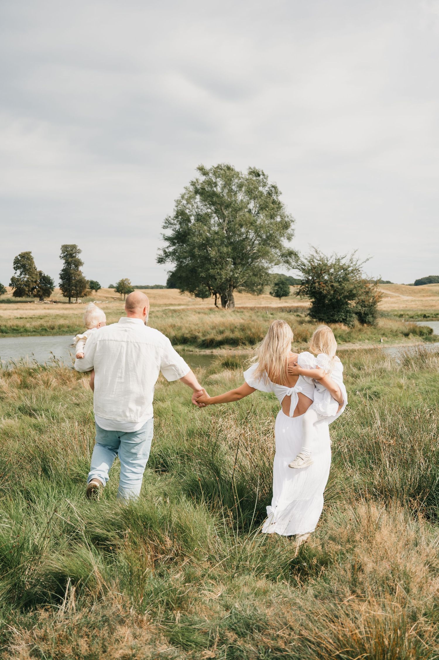 Familie går en tur i det høje græs i Dyrehaven