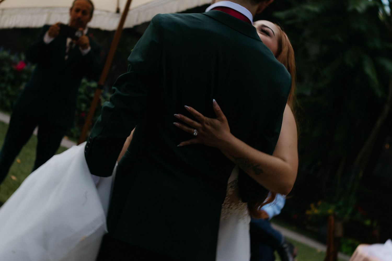 A couple shares a tender moment during their outdoor wedding ceremony surrounded by greenery and natural light.