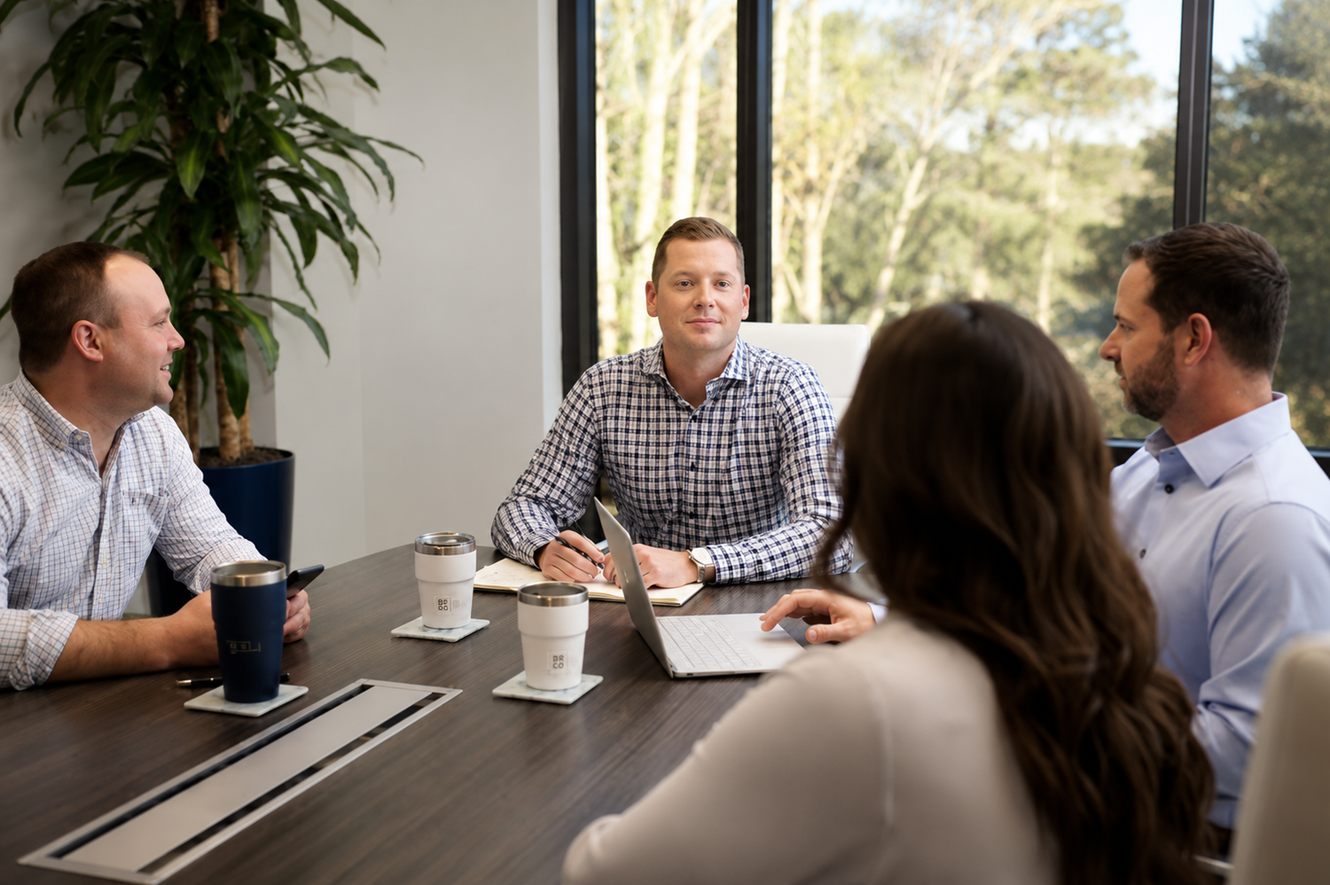 Business professionals engaged in a productive meeting around a conference table in a modern office setting.