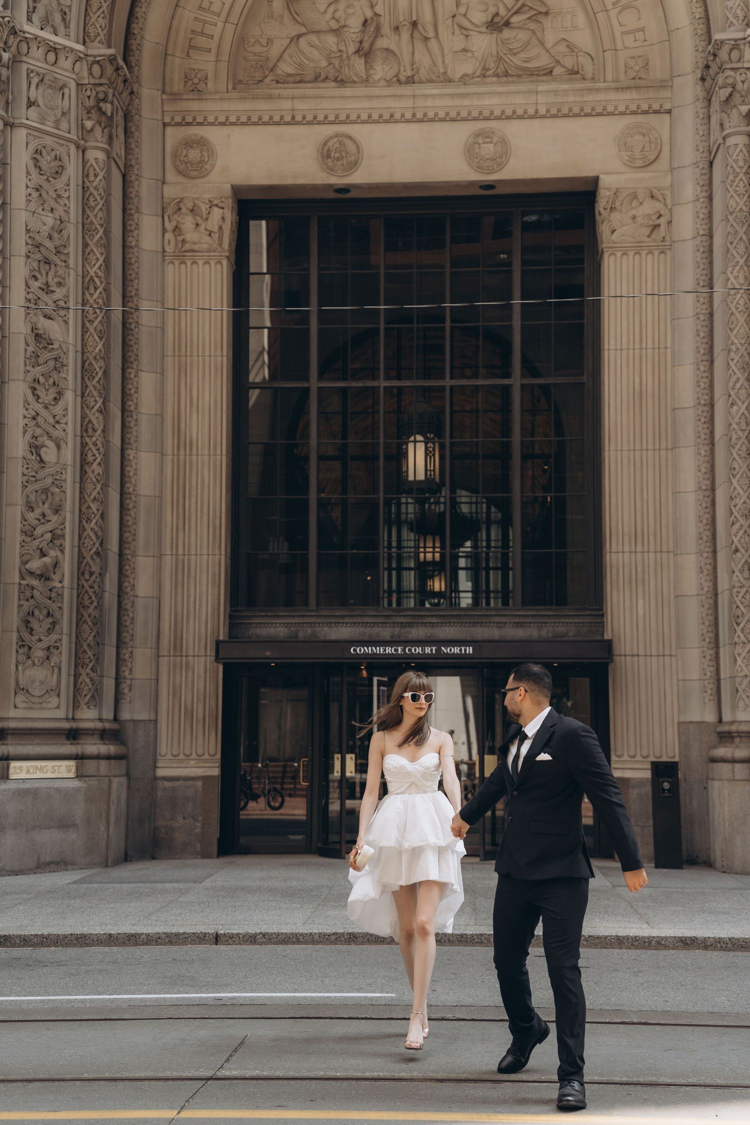A series of connected photos showing a couple walking together in front of an ornate architectural entrance.