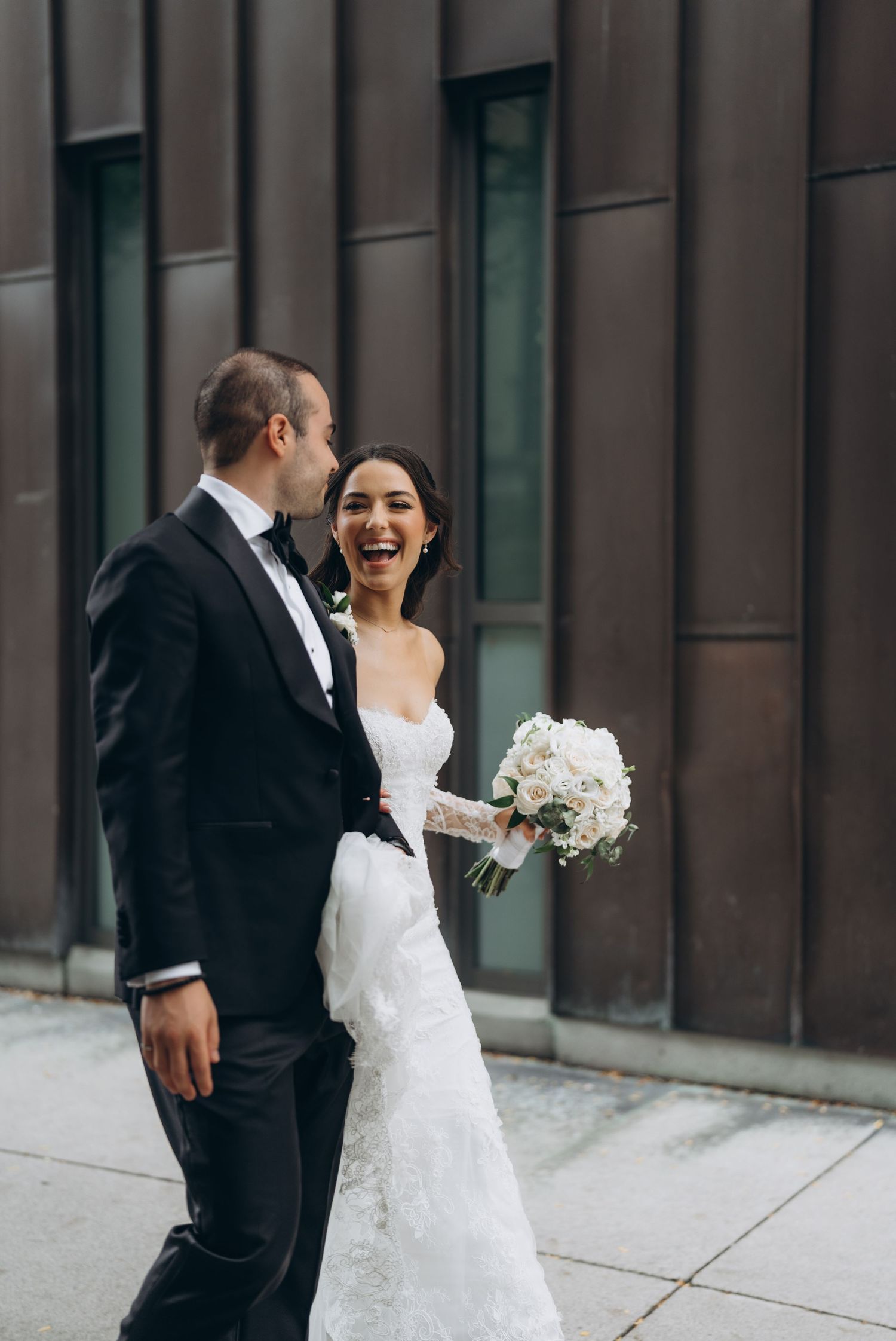 A happy bride and groom share candid laughing moments in a series of black and white wedding photos against a modern wall.