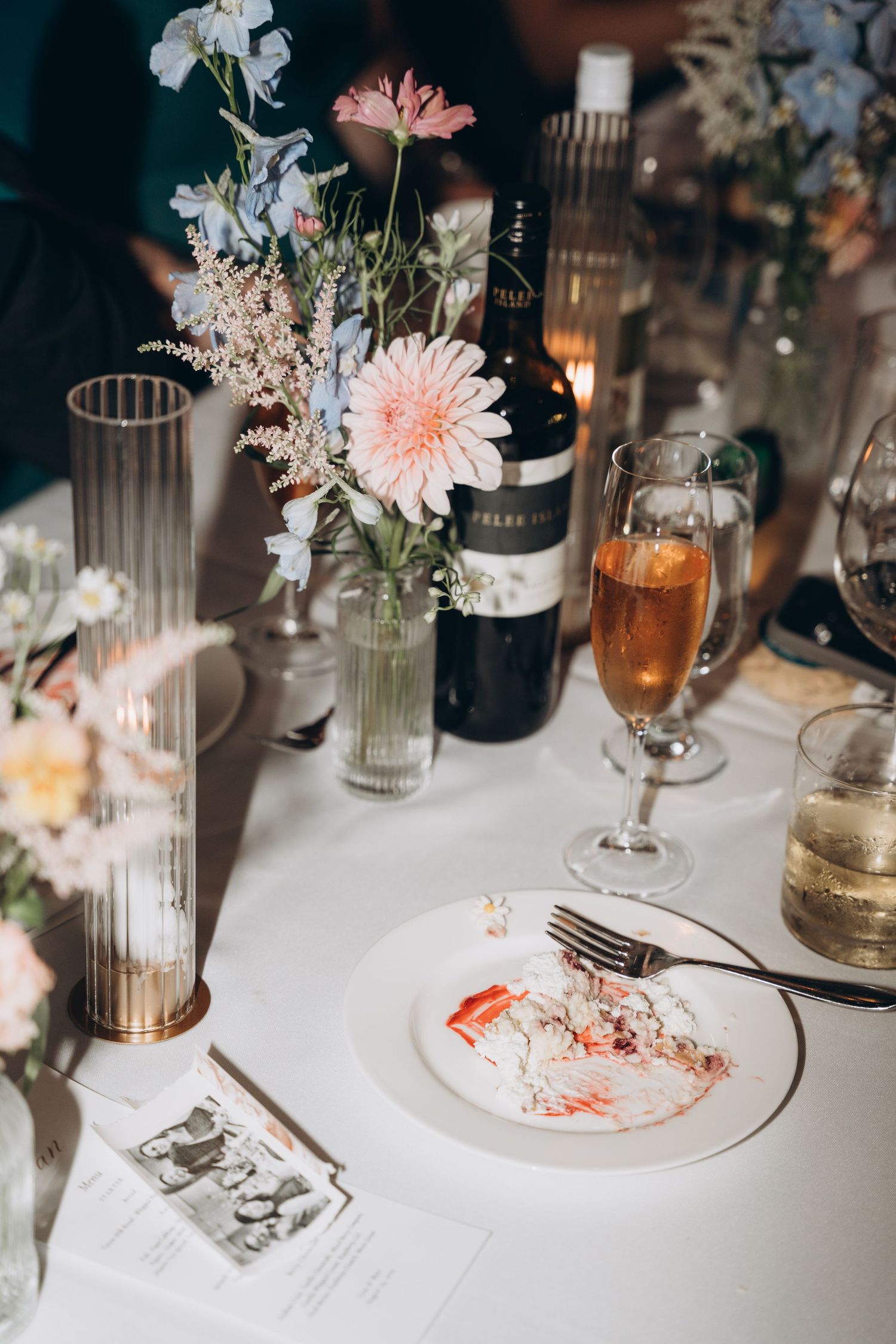 Wedding reception table settings with delicate floral centerpieces, glassware, and soft candlelight create an elegant atmosphere.
