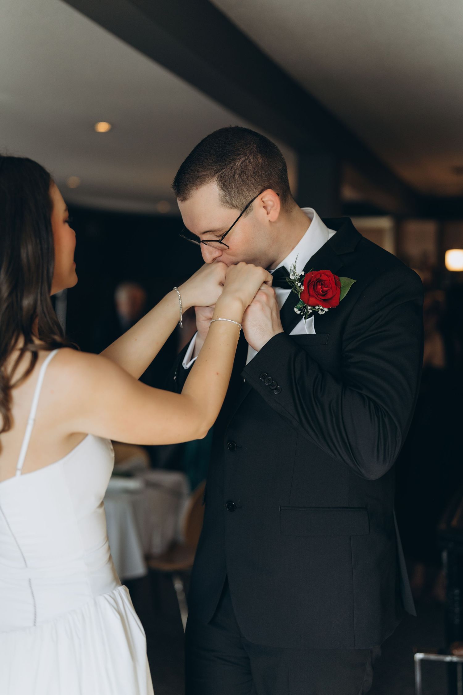 A romantic first dance sequence between newlyweds in formal wedding attire at their reception.