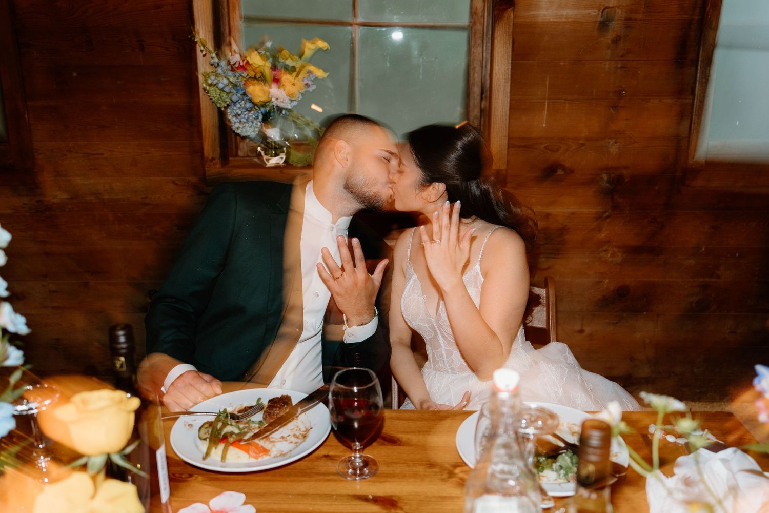 Romantic candlelit dinner setting at a rustic wooden table with wine glasses and intimate ambiance.