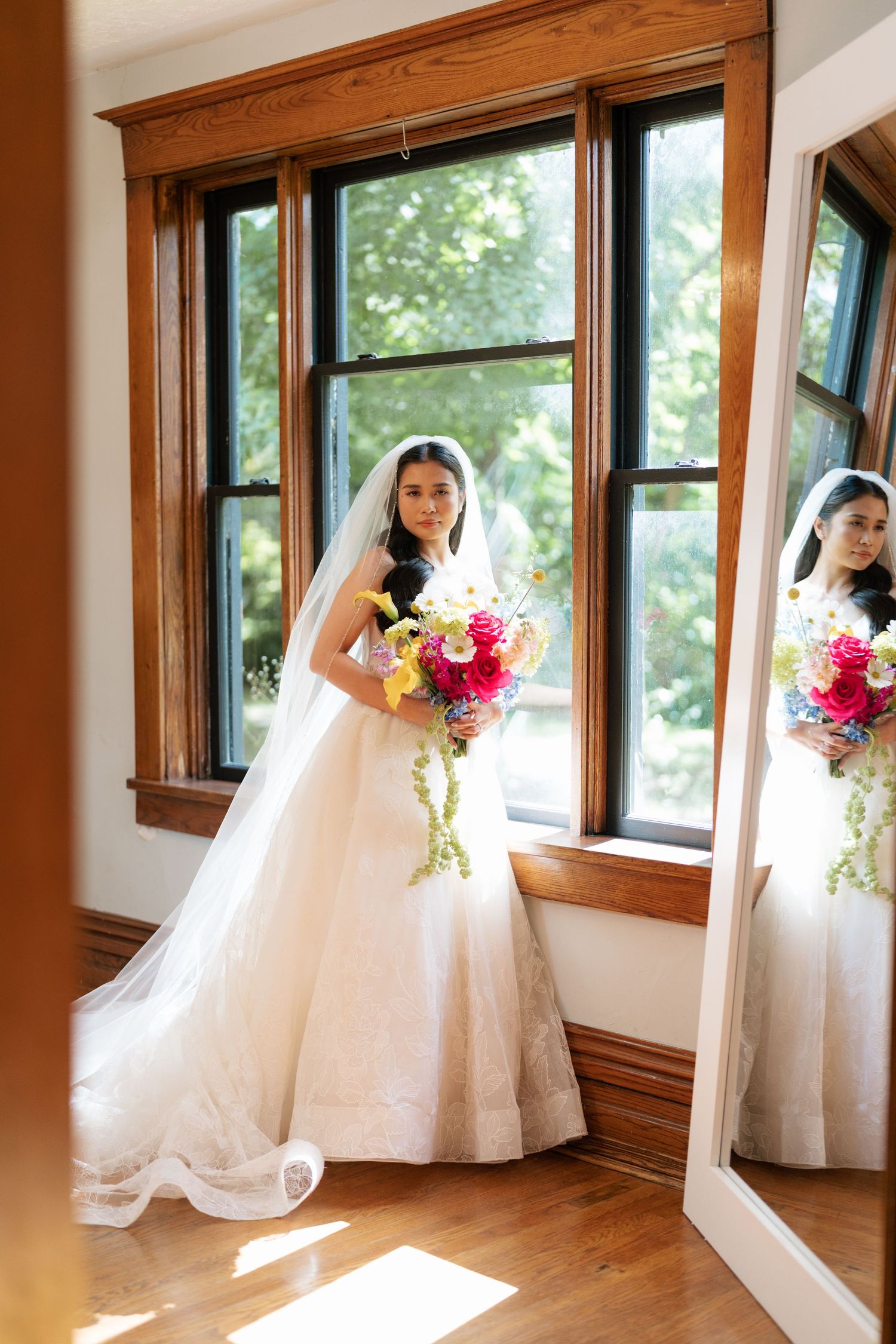 Artistic wedding photo series showing a bride in white dress by sunlit windows with pink and yellow bouquet.