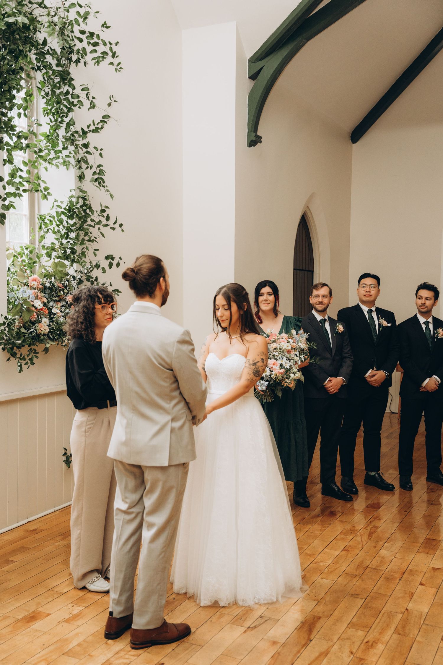 A sequence of four wedding reception photos showing a first dance on a wooden floor with guests watching from the side.