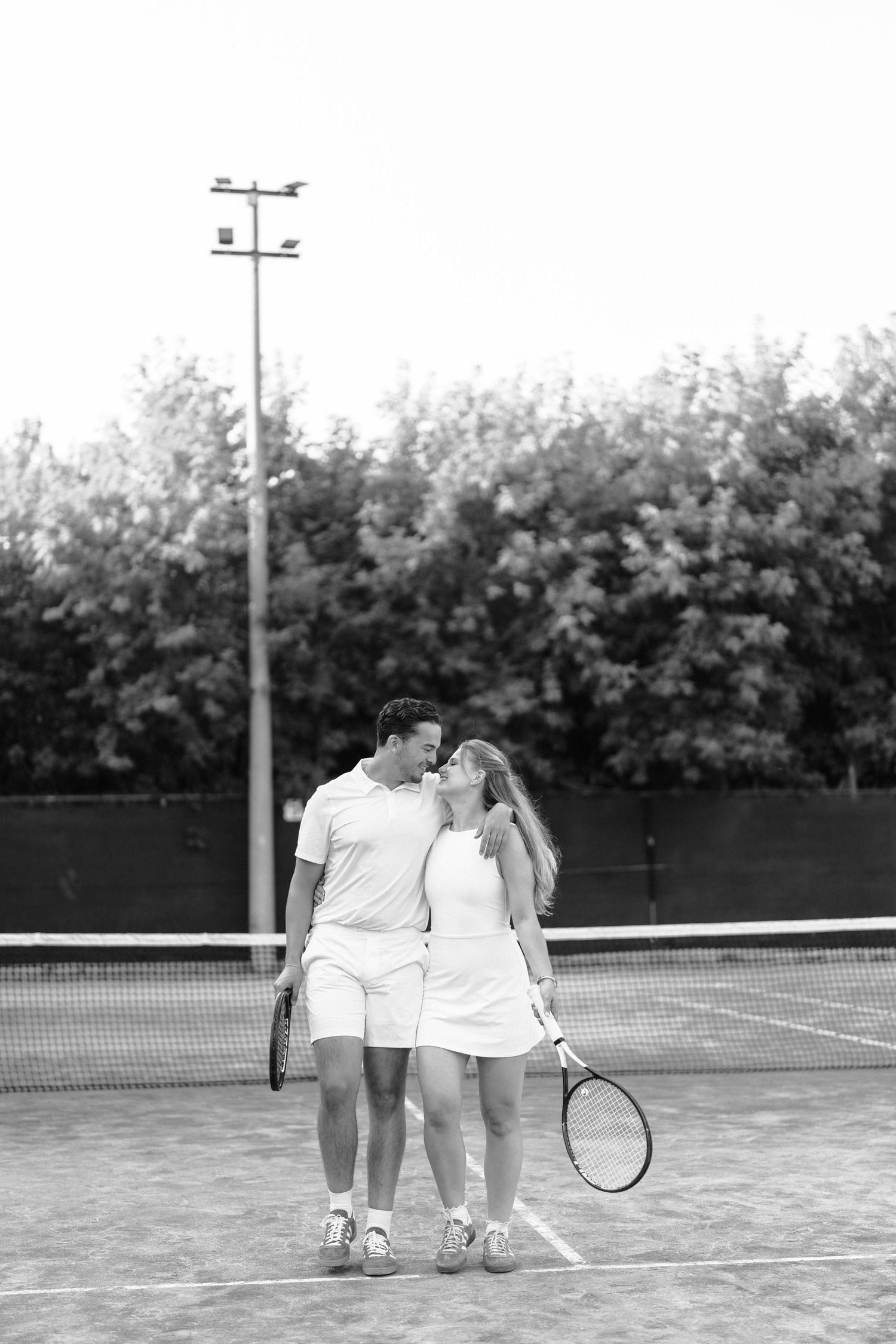 Three black and white photos showing a romantic scene on a tennis court with players in vintage white tennis attire.