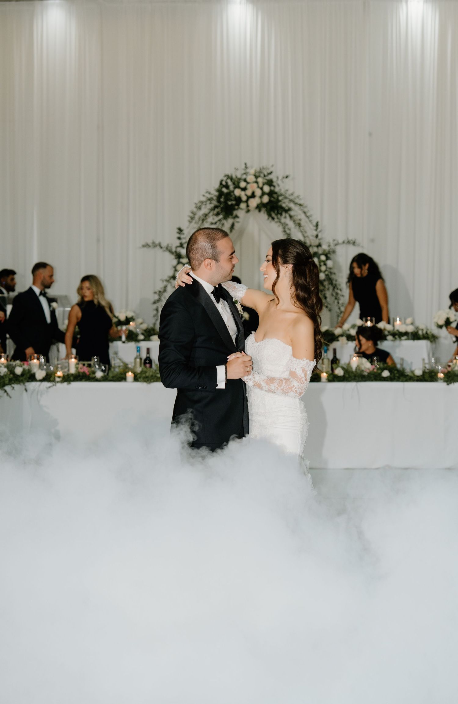 A romantic first dance at a wedding reception with fog effects creating a dreamy atmosphere on the dance floor.