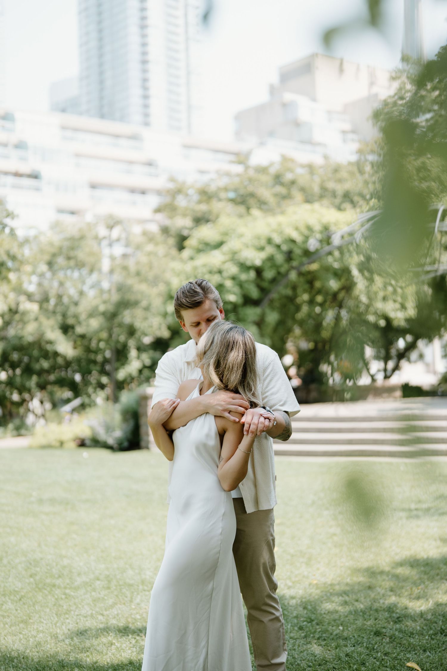 A romantic outdoor wedding scene shows two people sharing an intimate moment in a garden setting.
