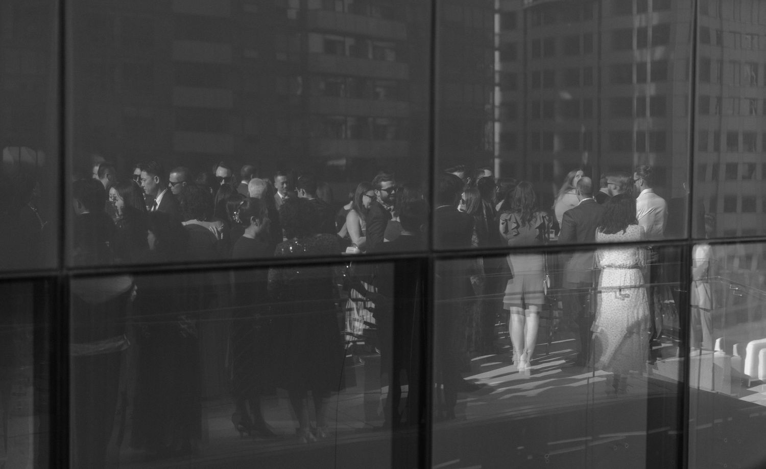 Black and white urban cityscape featuring tall residential buildings with glowing windows at night.