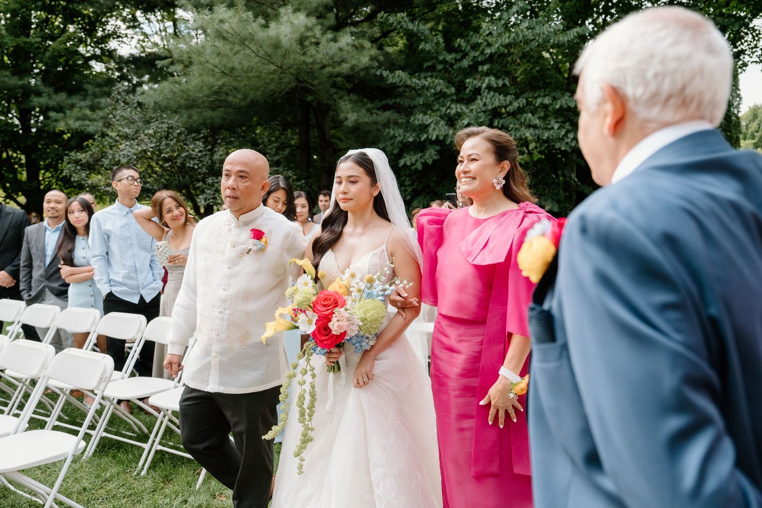 Wedding guests celebrate with joy and laughter during an outdoor garden ceremony.