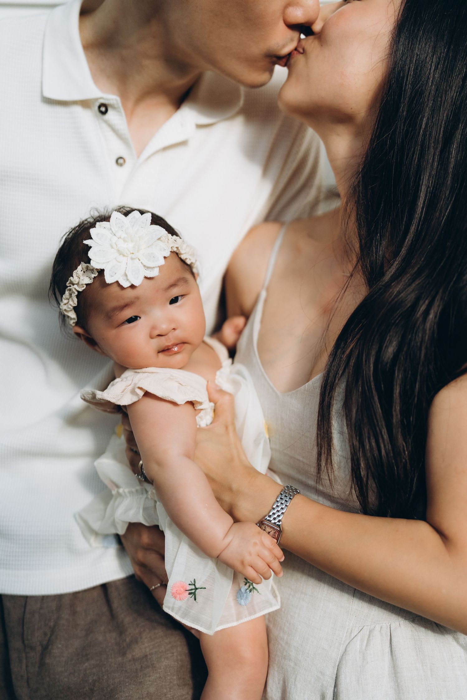 A tender family moment captured in soft lighting showing gentle interactions with a small baby.