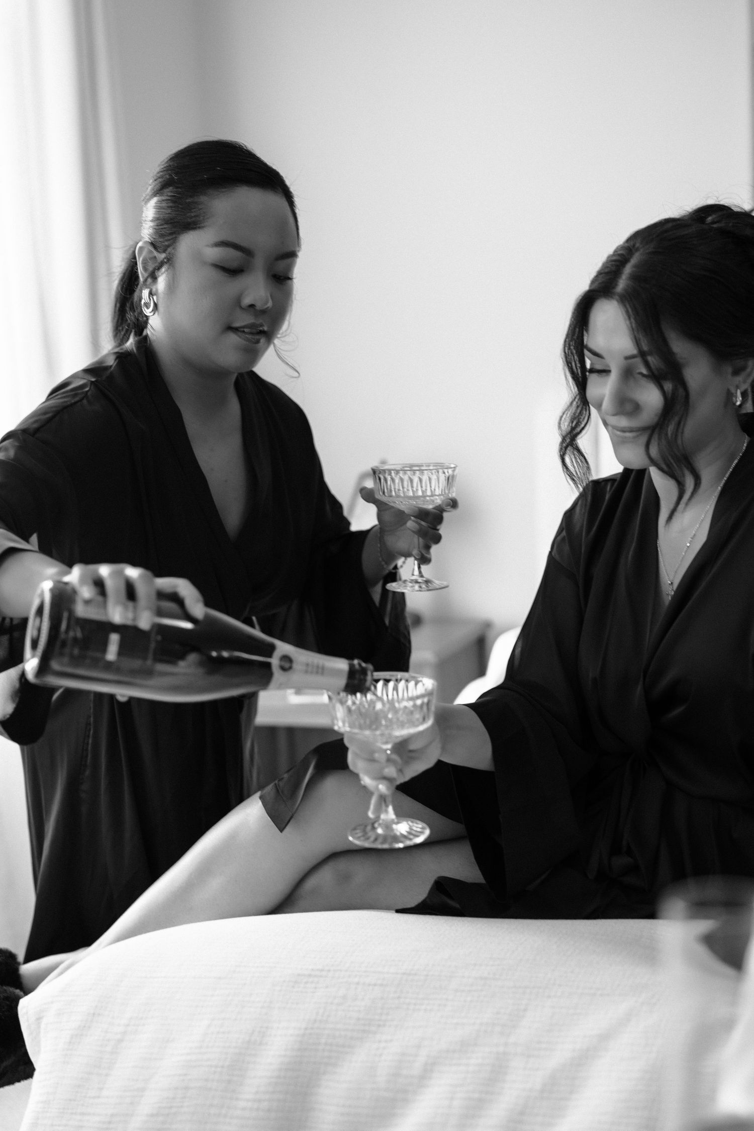 A black and white photo series showing someone in dark clothing sitting at a table with a drinking glass.