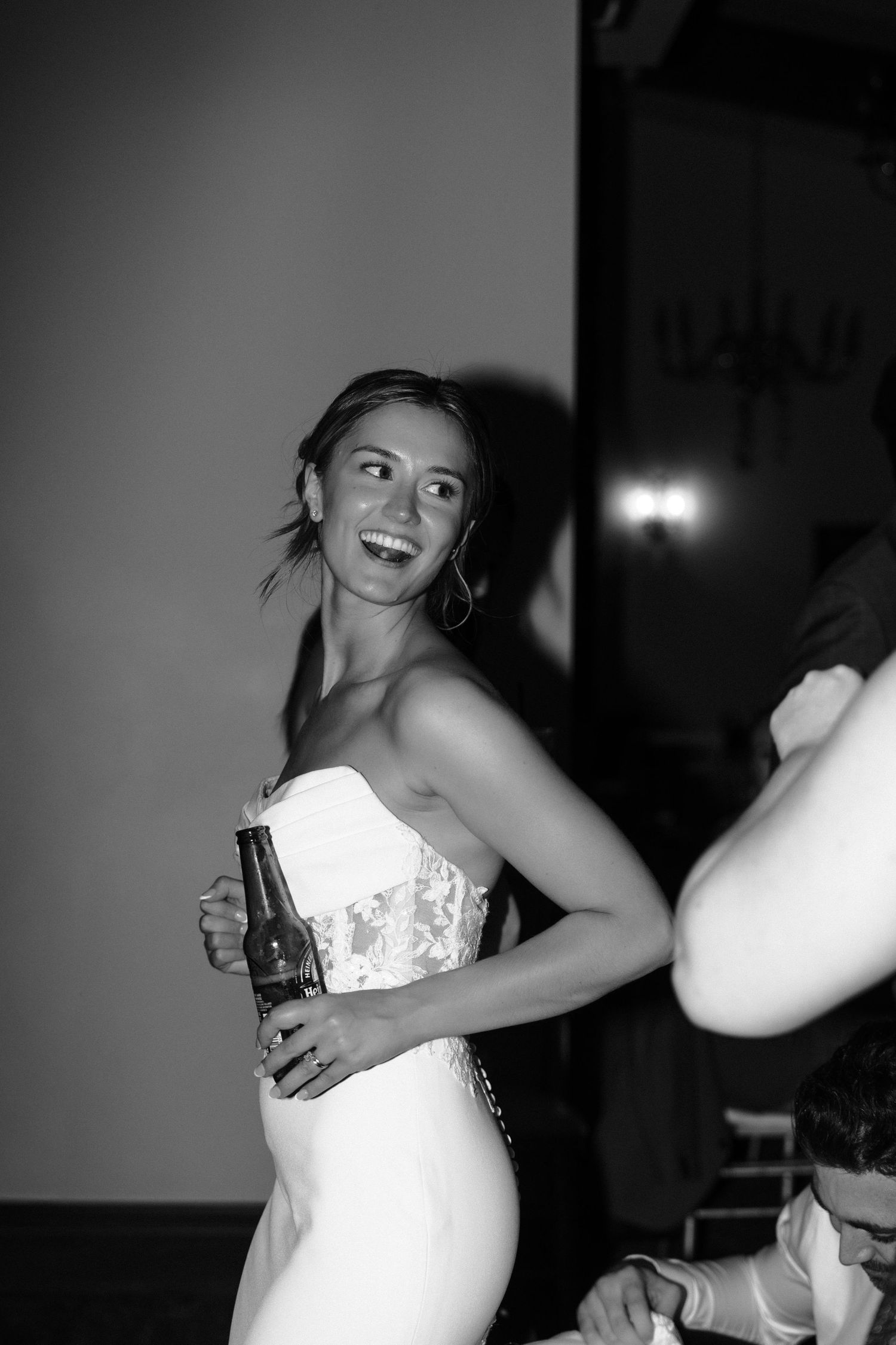 Black and white photo sequence shows a person in a white wedding dress dancing and laughing joyfully at a celebration.